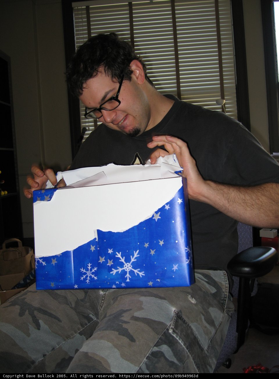 Man Unwrapping Gift on Christmas Eve