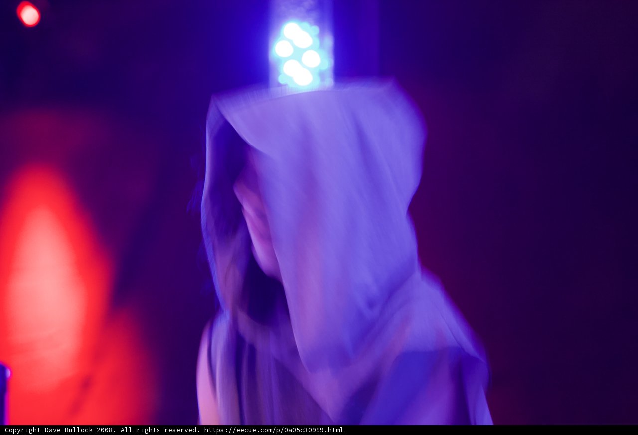 Hooded Figure Caught in Red Light