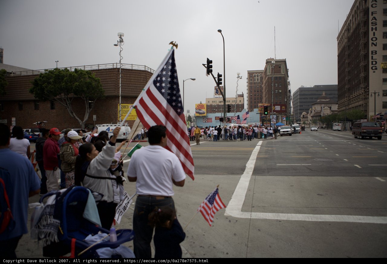 Great American Boycott Protestors Hold Two Flags on City Corner