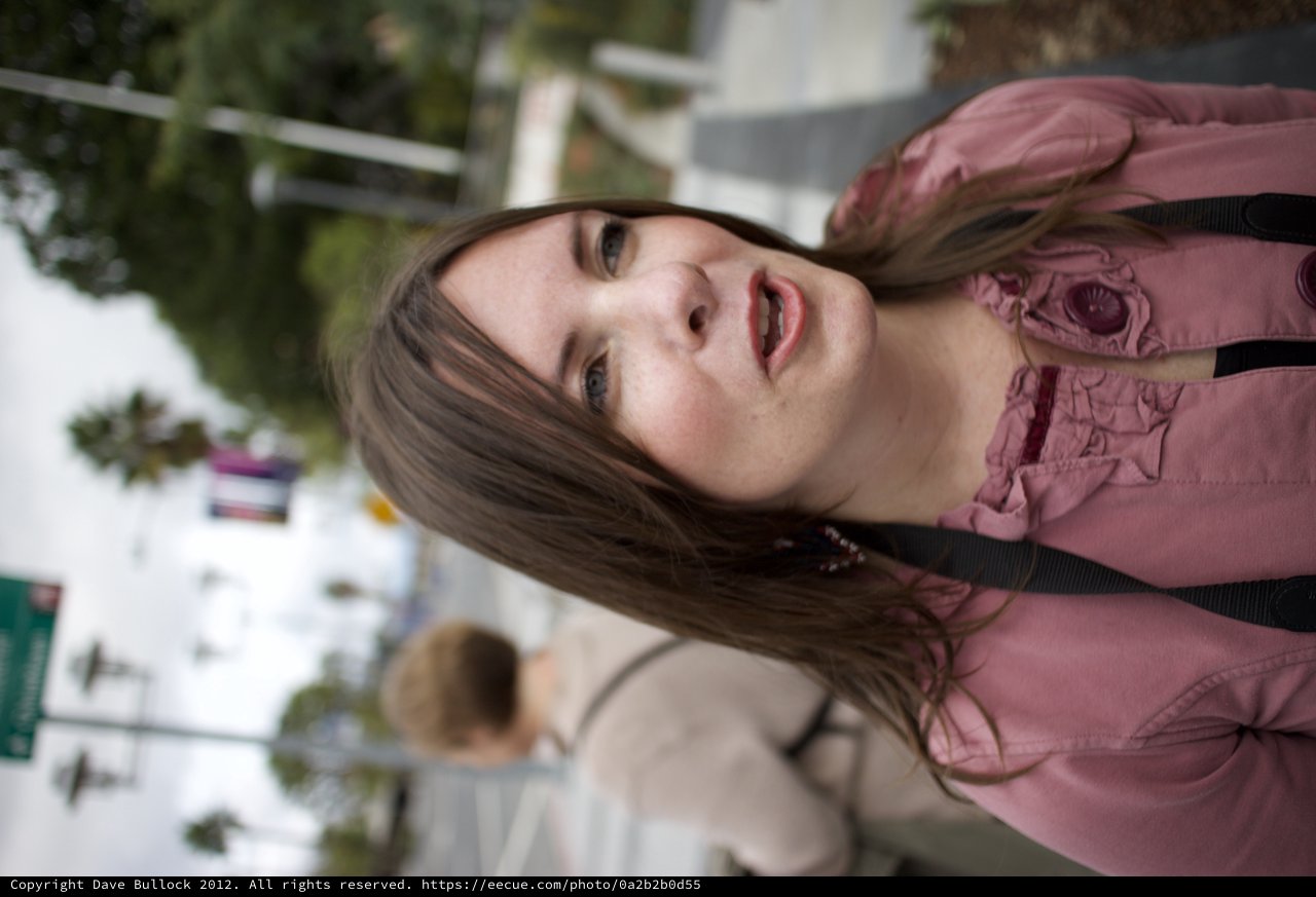 Woman in Pink Jacket on Urban Street Corner