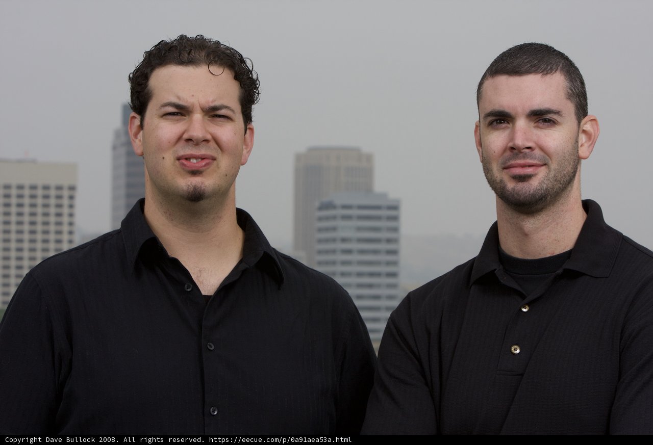 Two Happy Men Standing in Front of a Skyscraper