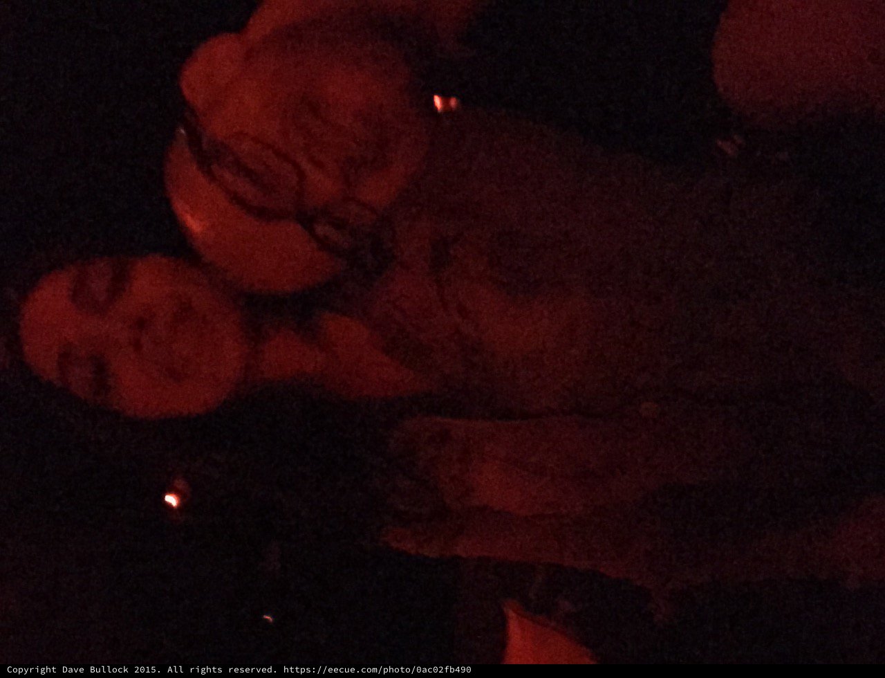 Two Friends Sharing a Moment in Red-Lit Darkness