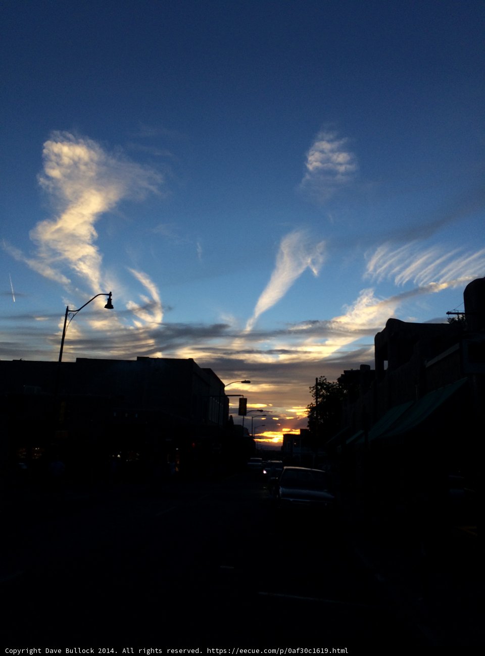 Sky filled with clouds at sunset over a city