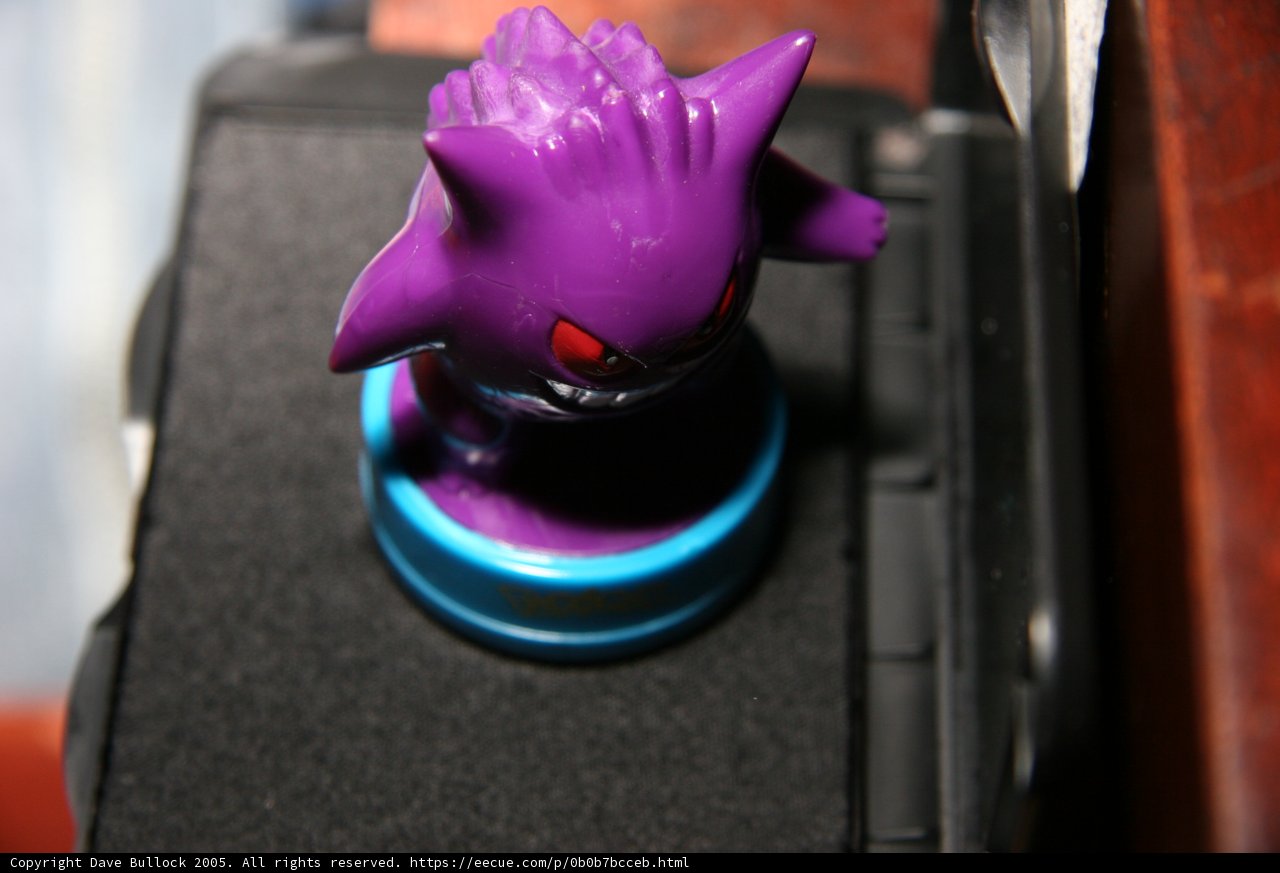 Purple Figurine on Top of Black Case