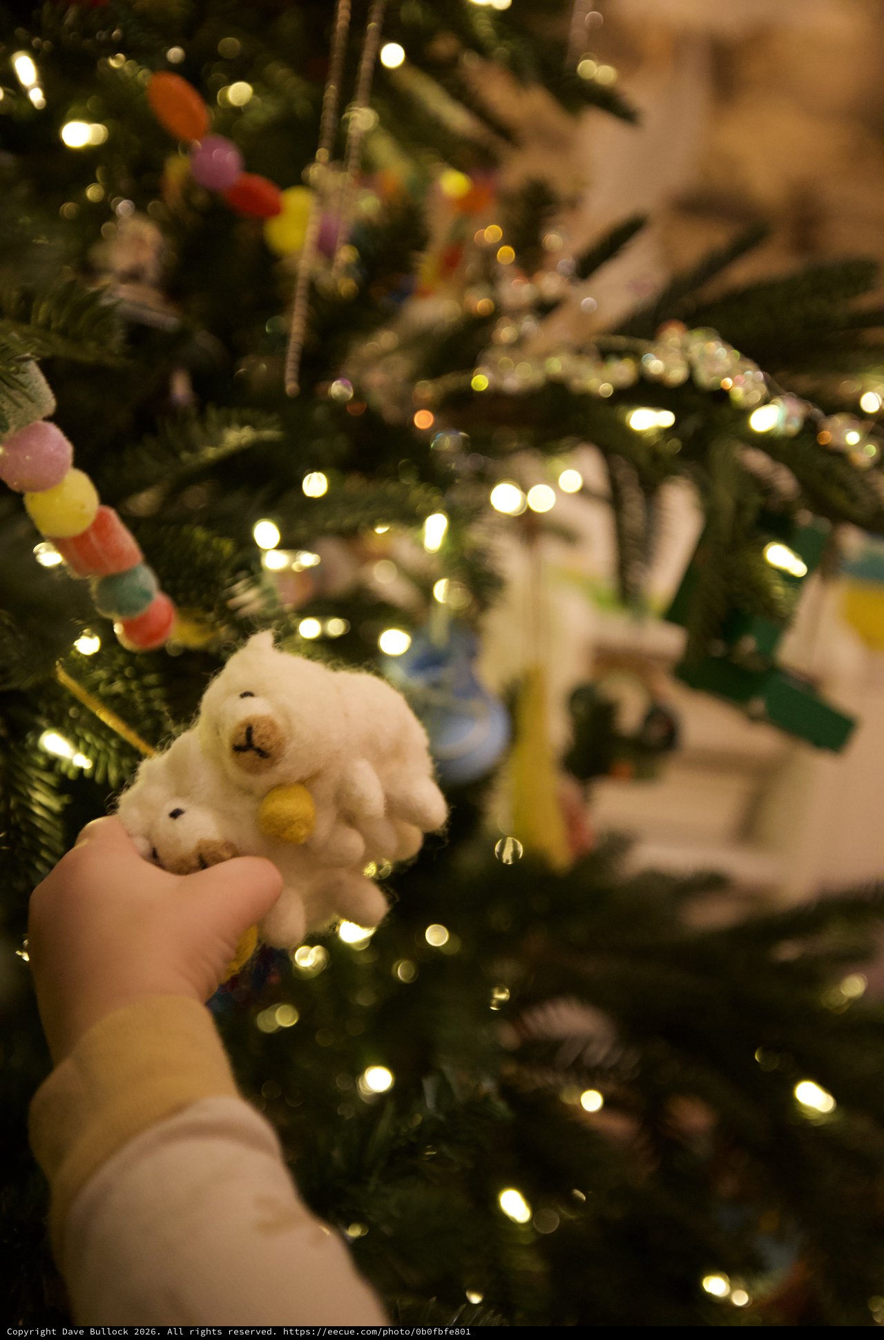 Child's Hand Holding White Snowman Christmas Ornament