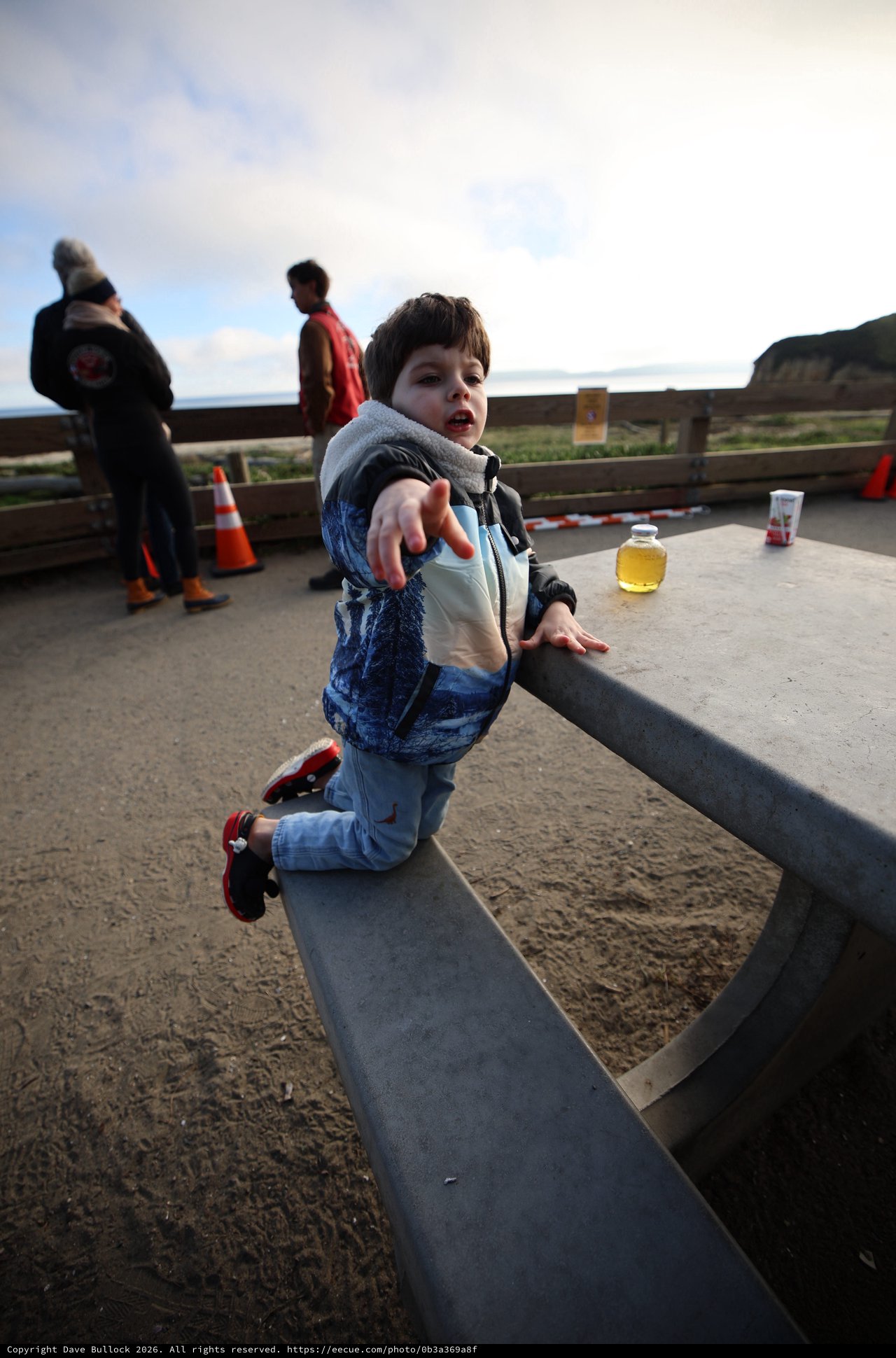 Young Child Balancing on Curved Bench at Coastal Overlook