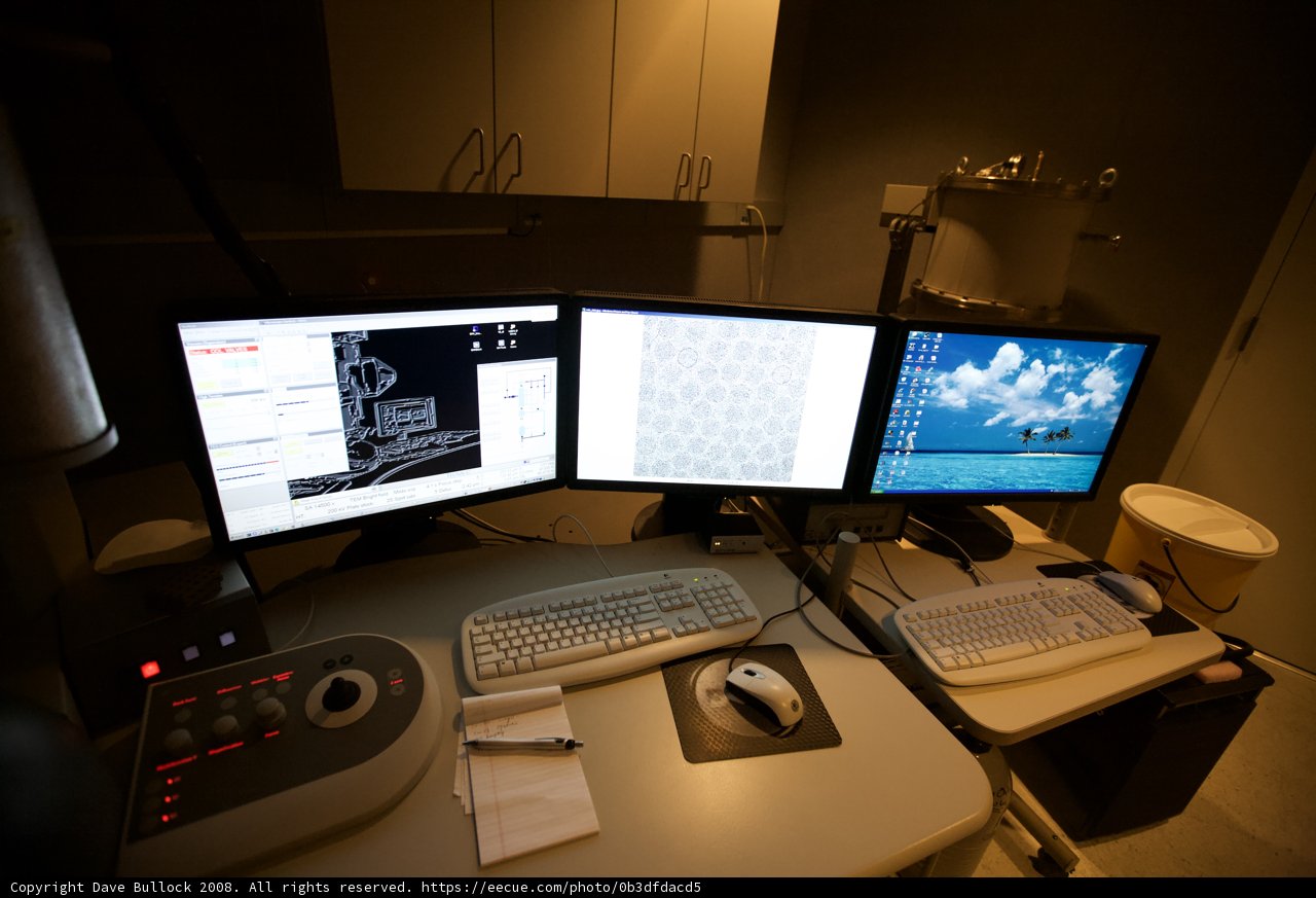 Three Computer Monitors on a Desk