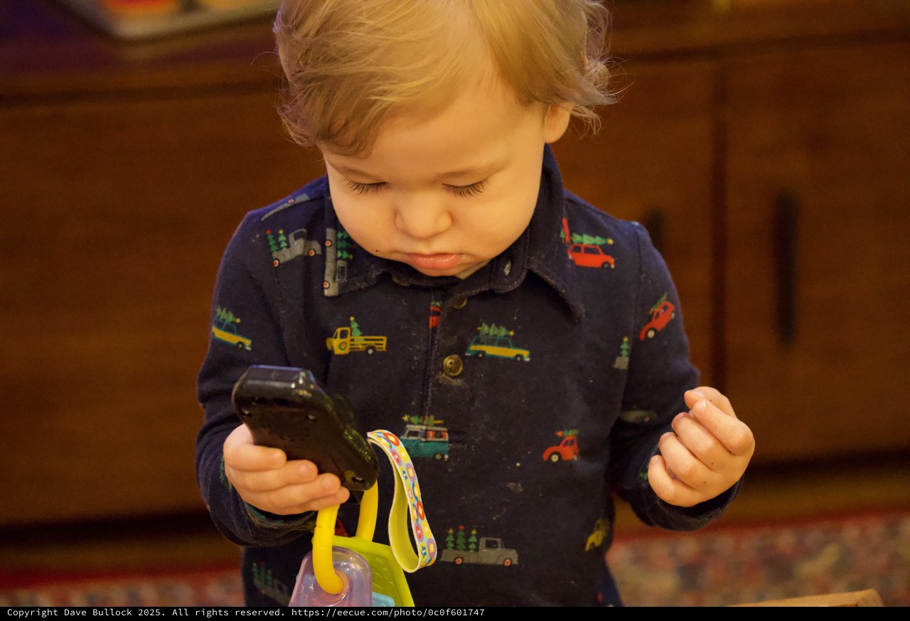 Toddler Mesmerized by Toy Vehicle at Christmas