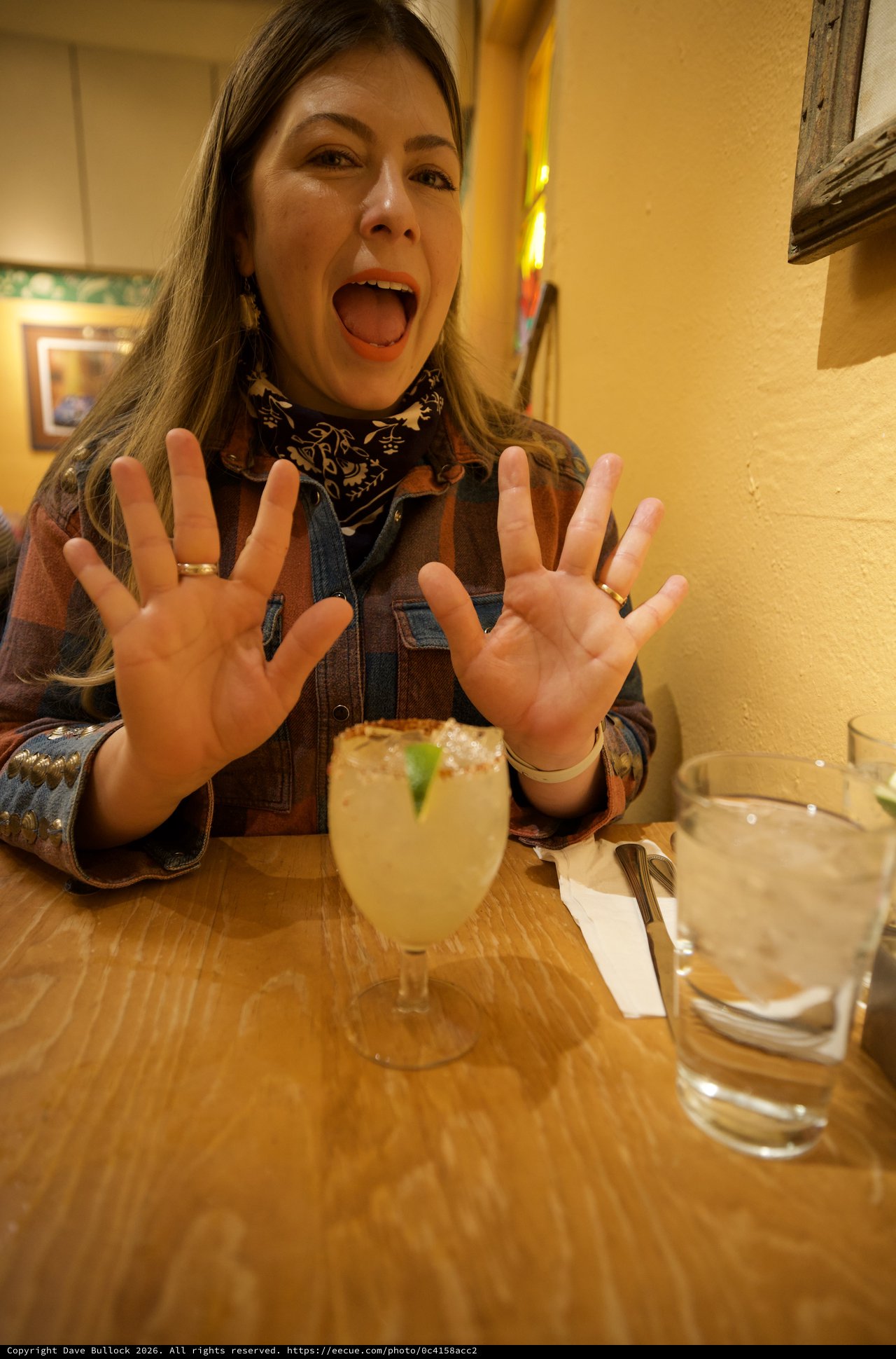 Enthusiastic Woman Celebrating with Margarita at Restaurant
