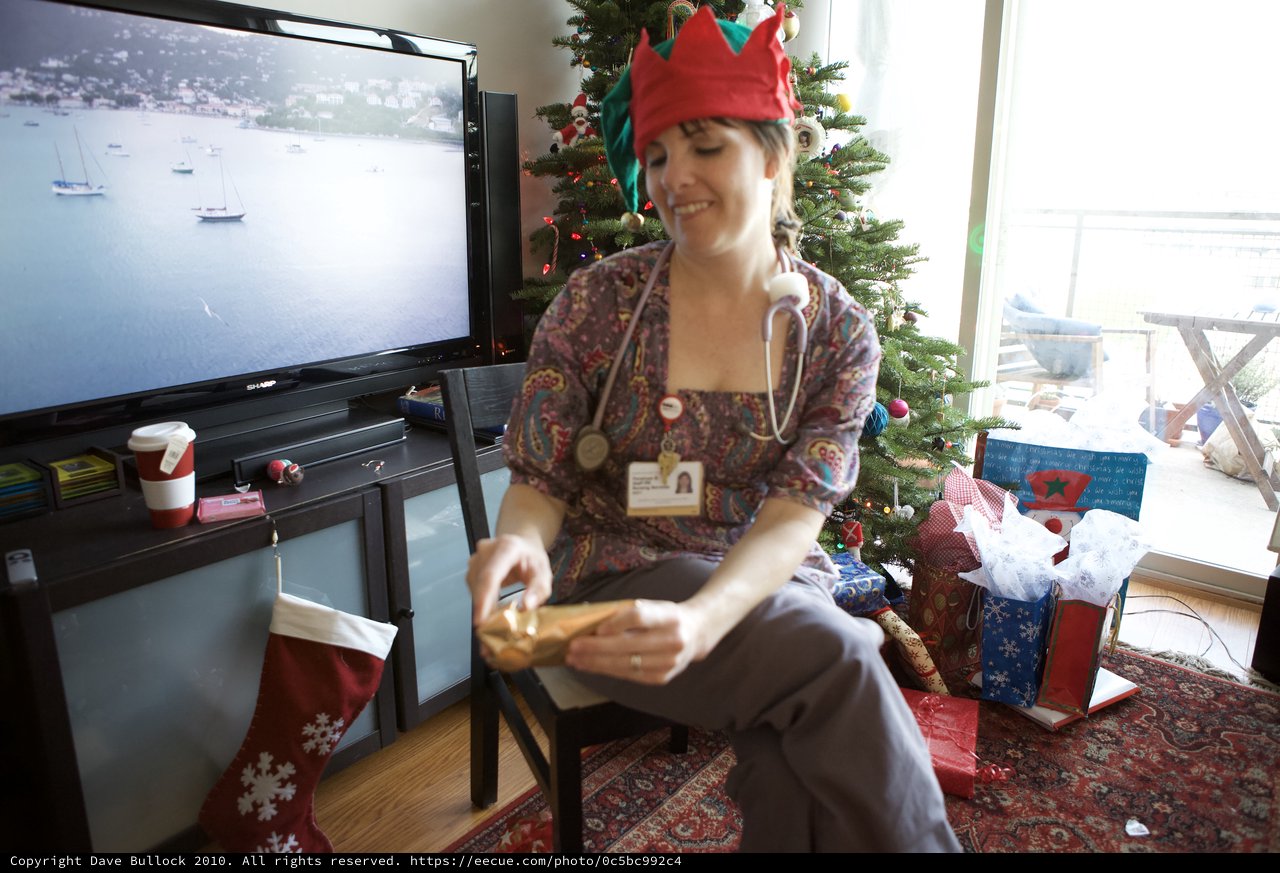 Nurse in Elf Hat Opens Christmas Gifts at Home
