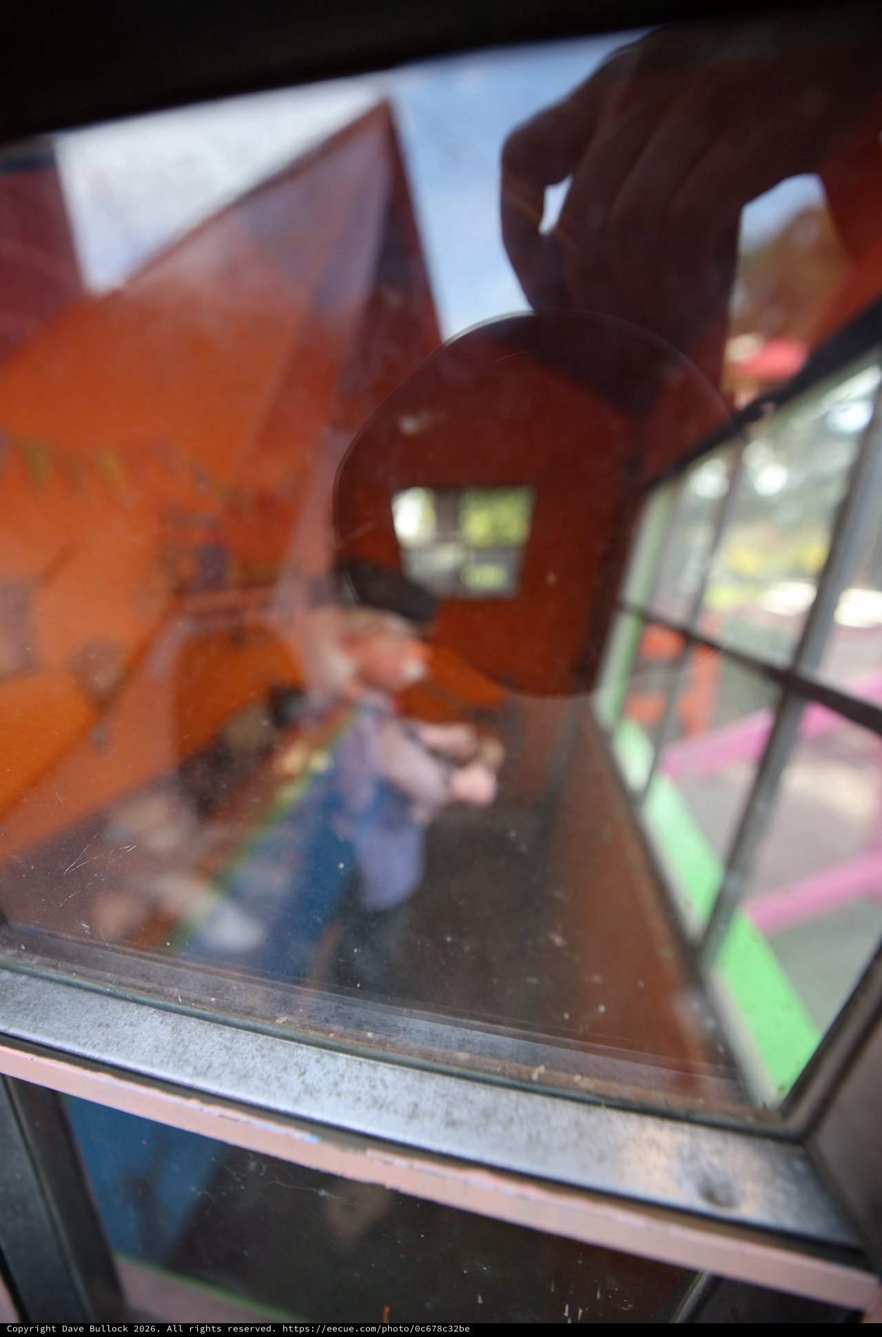 Hand Holding Toy Through Display Case Reflection