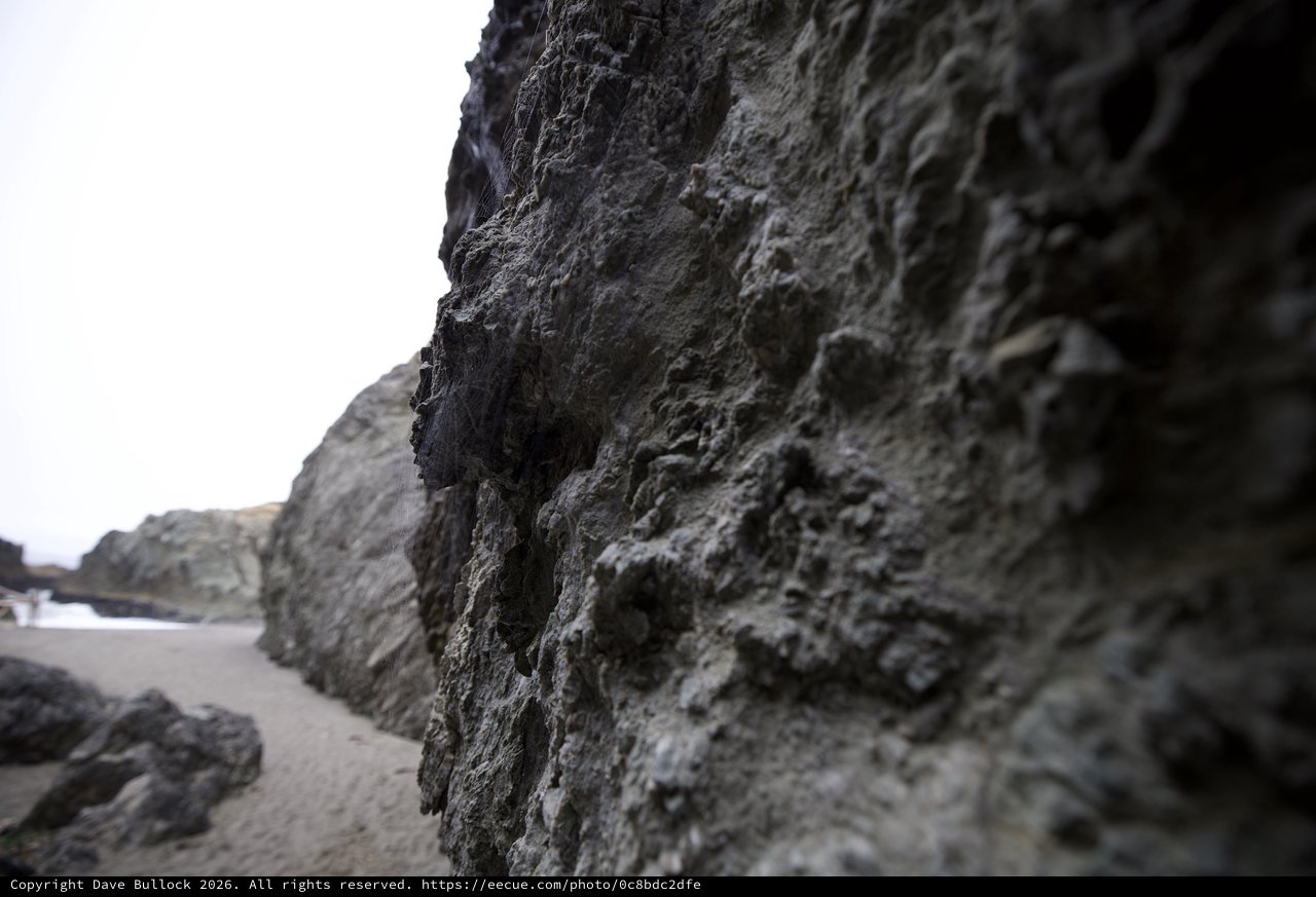 Rugged Coastal Rock Face at Low Tide Beach