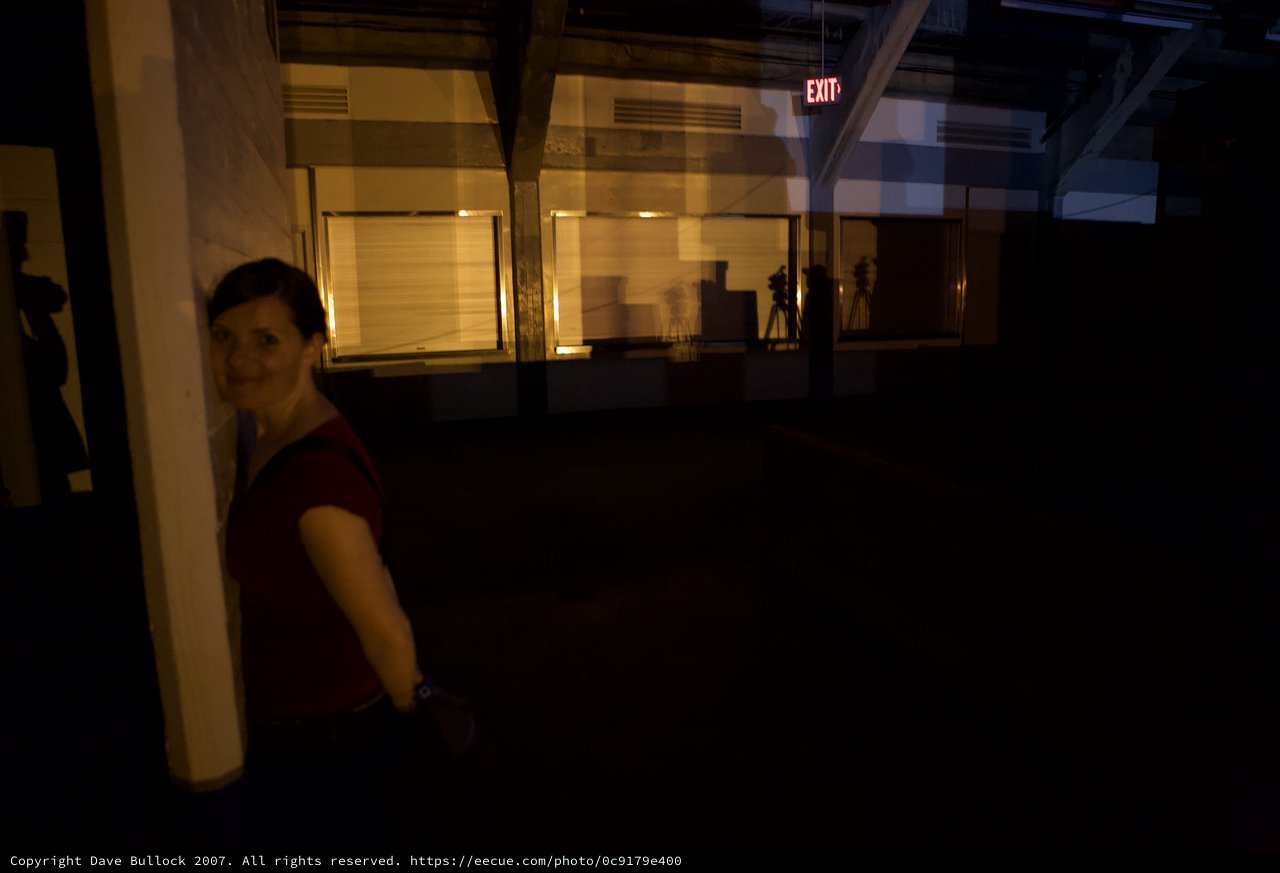 Woman Smiling in Dimly Lit Industrial Space