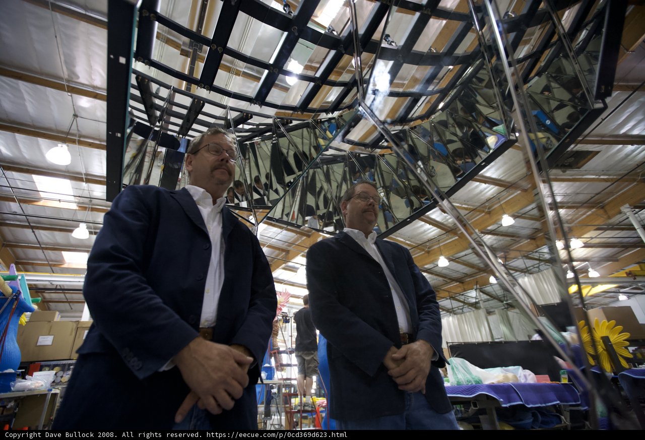 Two Men in Formal Wear Examining Themselves in a Factory Mirror