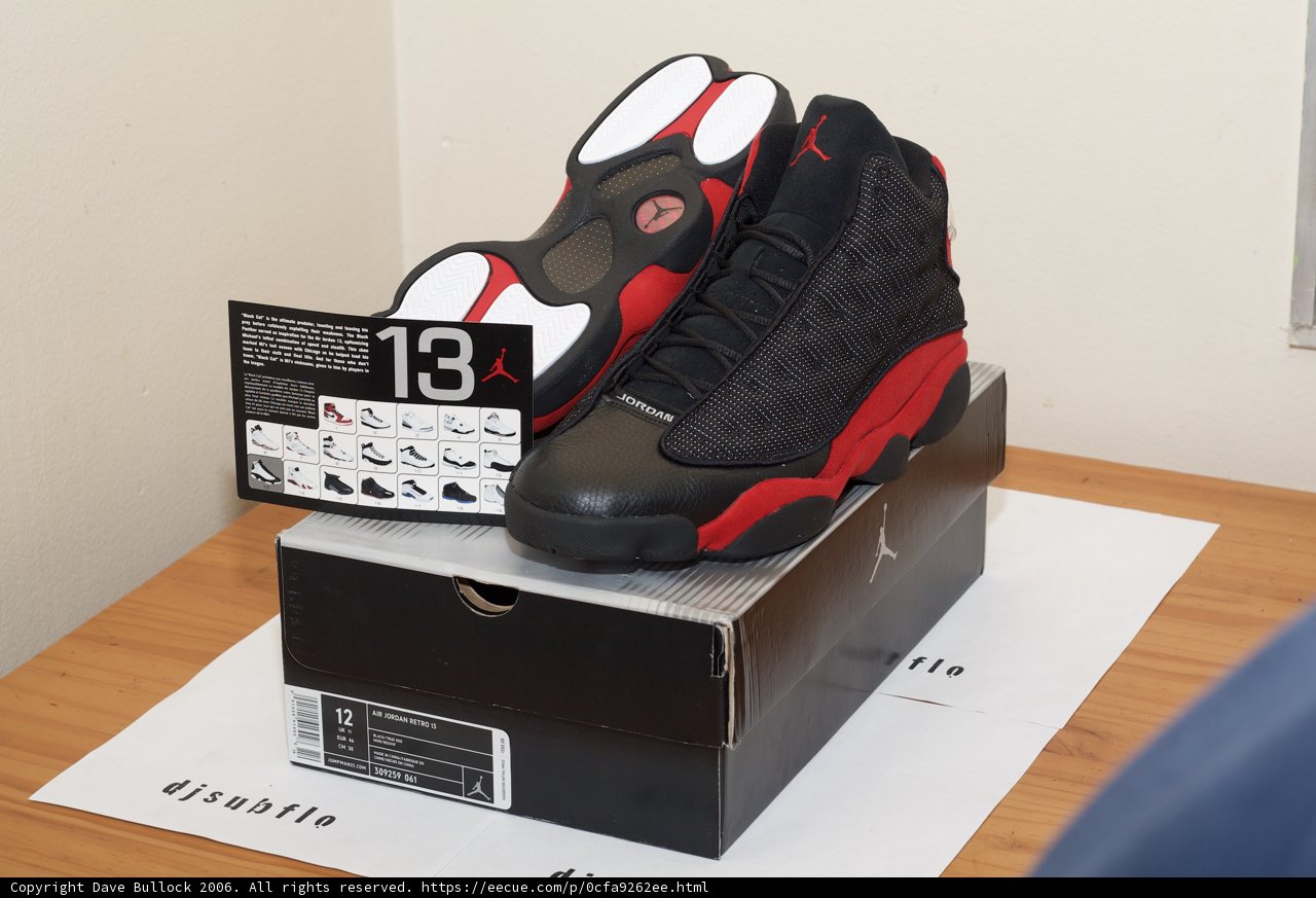 Air Jordan 13 Retro Black Red Sneakers on Hardwood Floor