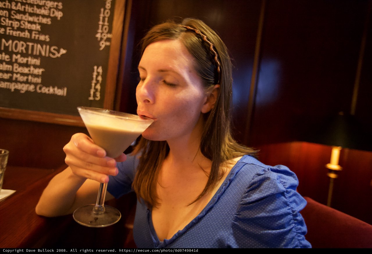 Woman Savoring a Creamy Martini at Upscale Bar