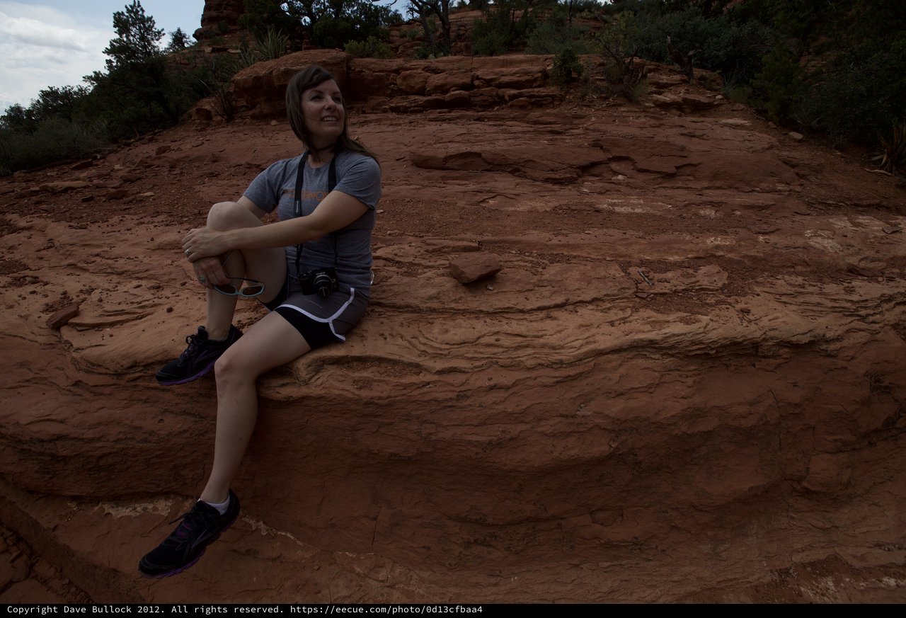 Woman Photographer Resting on Red Rock Formation in Sedona