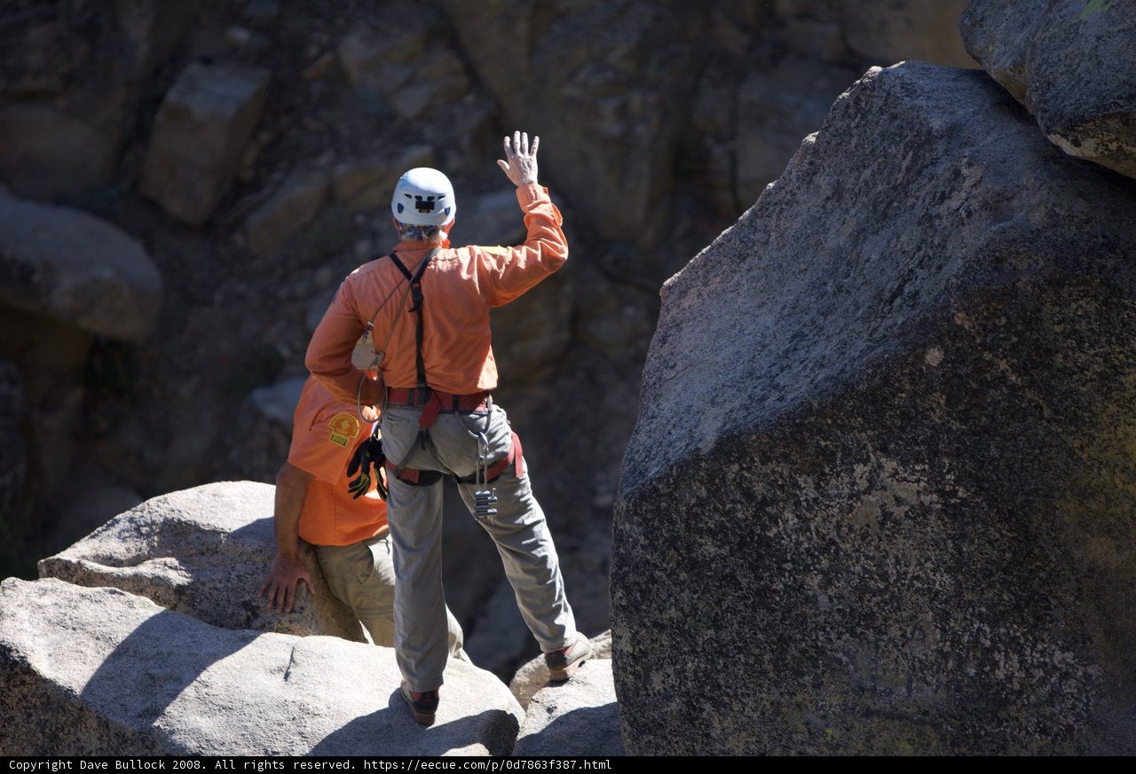 Orange-clad Man Scaling Rock