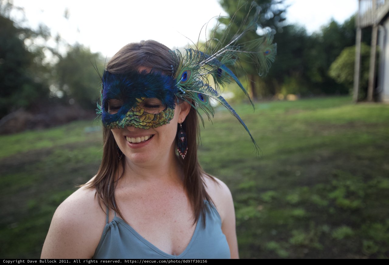 Smiling Woman in Peacock Feather Masquerade Mask