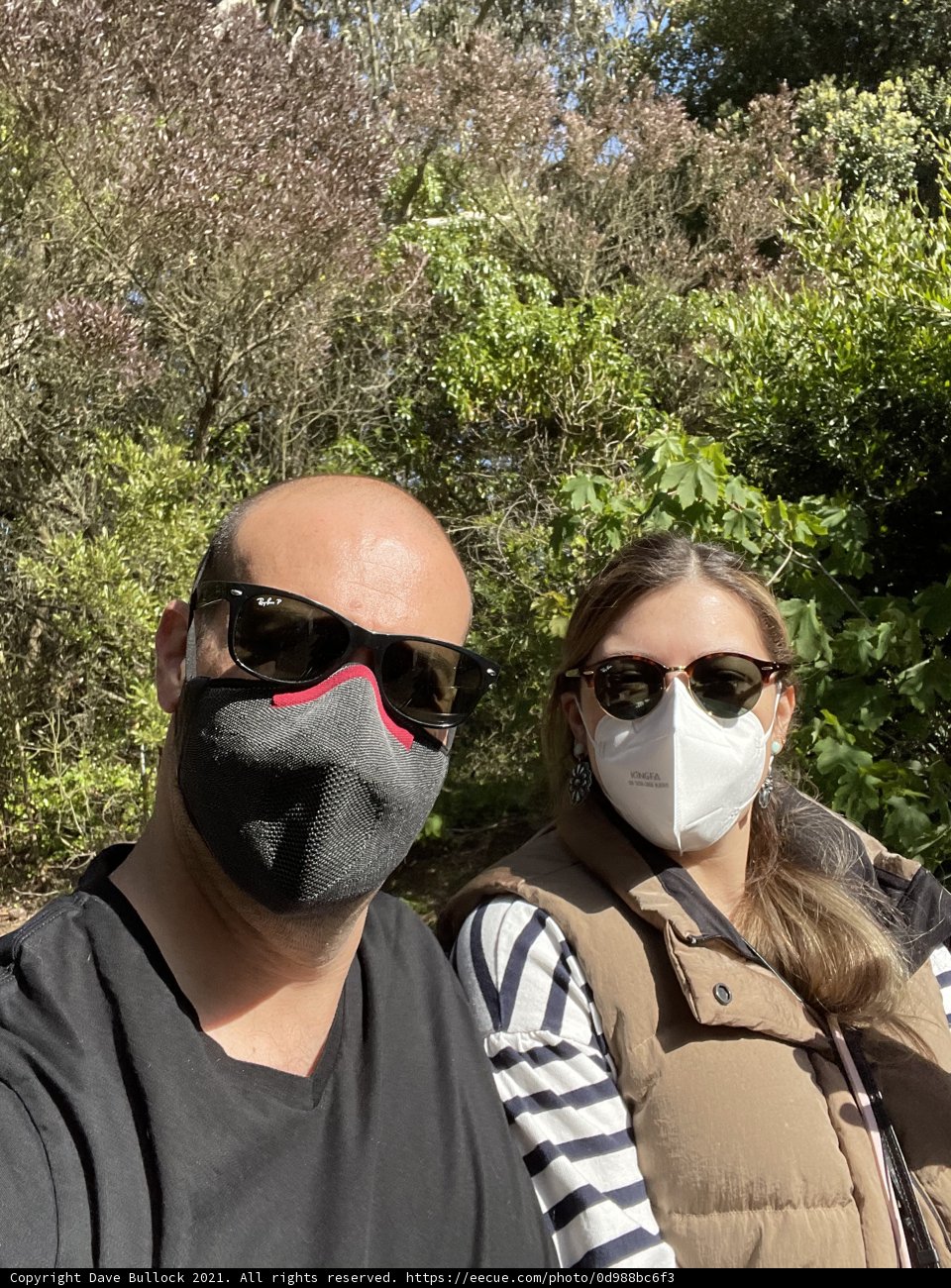 Two People Enjoying Nature while Wearing Masks in the Park