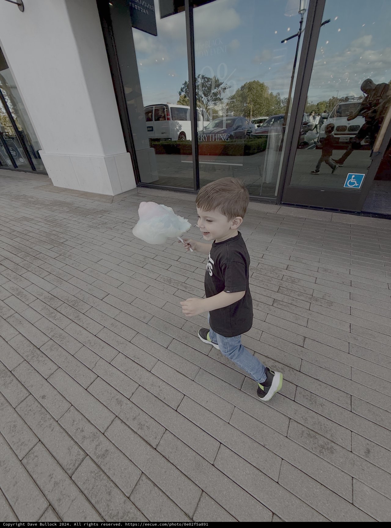 Young Boy Enjoying Cotton Candy Outside Store