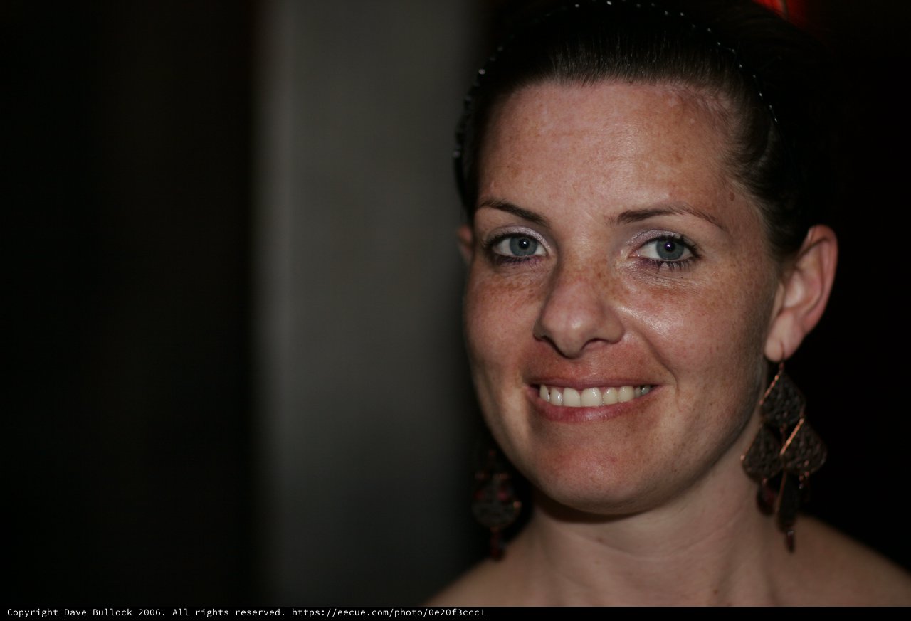 Freckled Woman Smiling Warmly at Evening Event