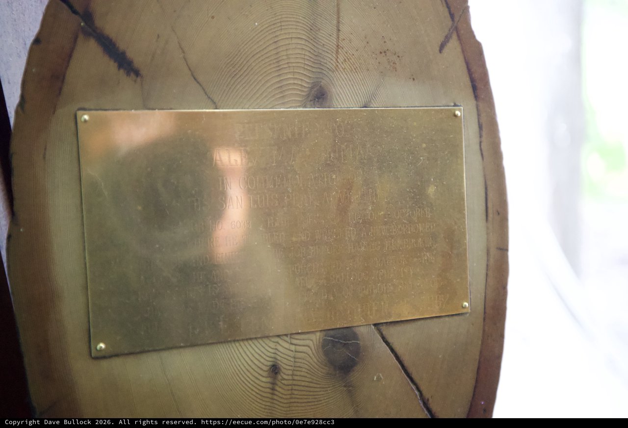 Weathered Brass Memorial Plaque on Wooden Post
