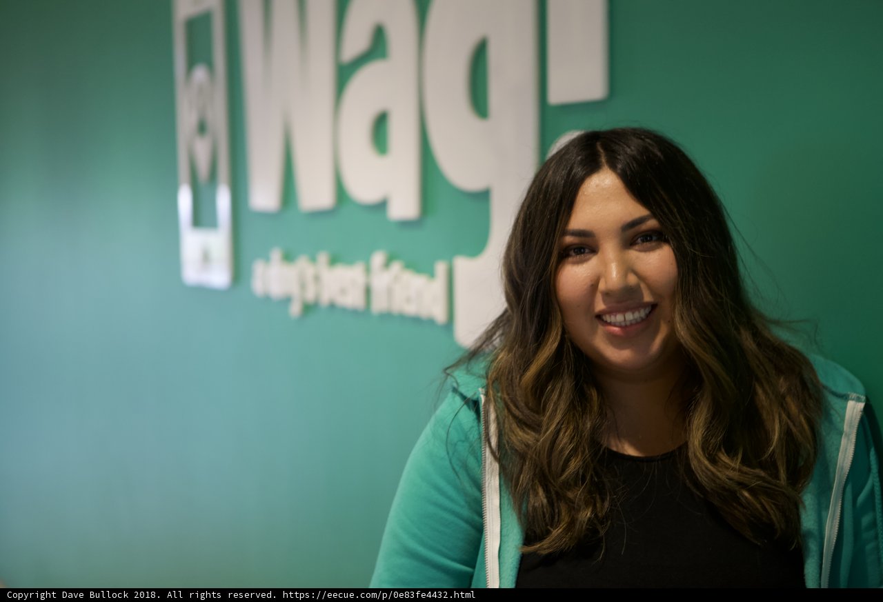 Smiling Woman Poses in front of WAG Logo