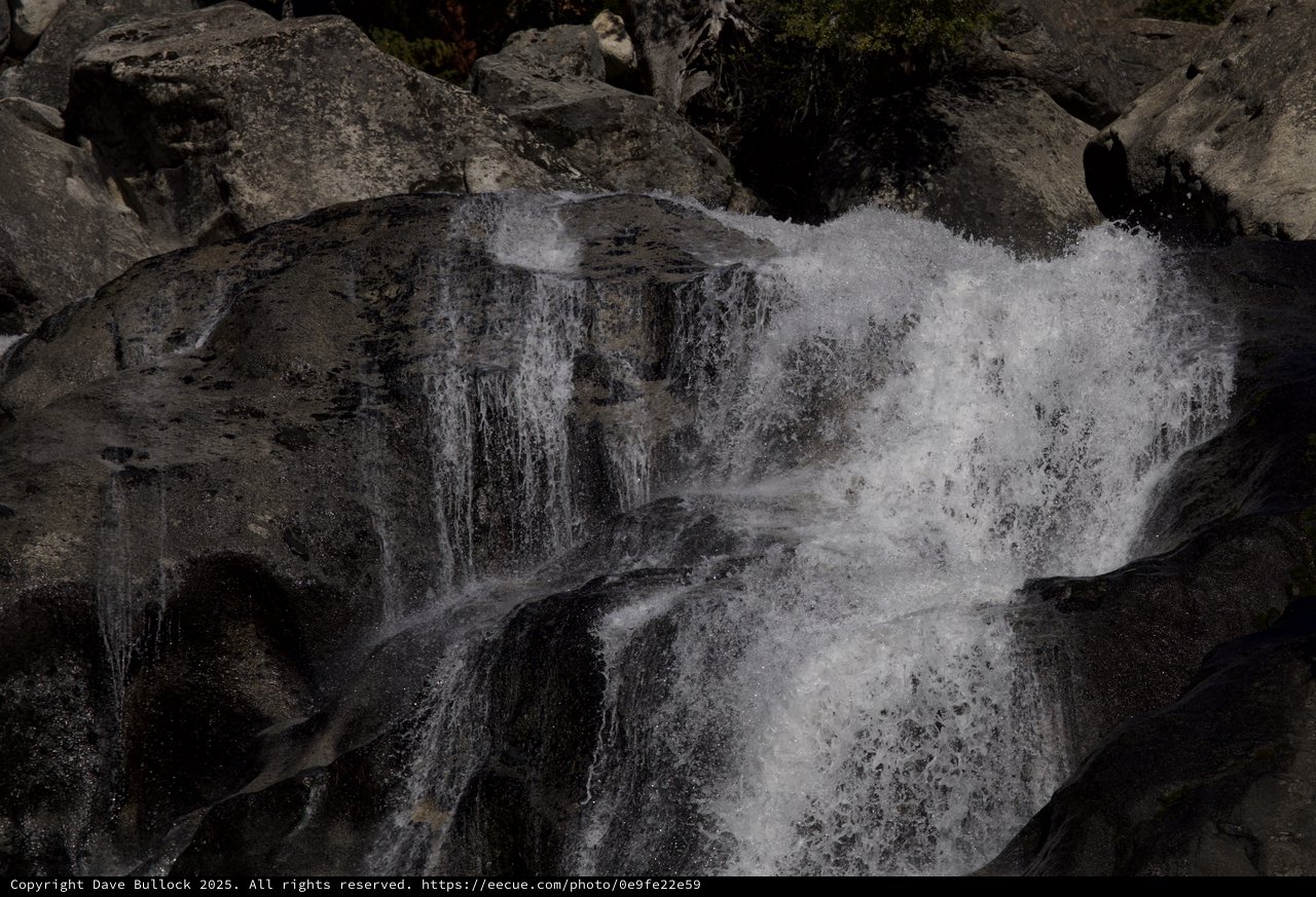 Cascading Waters Through Dark Rocky Terrain