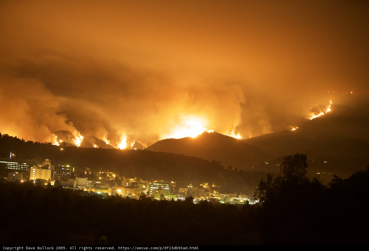 Flames Consume Hills Above Cityscape