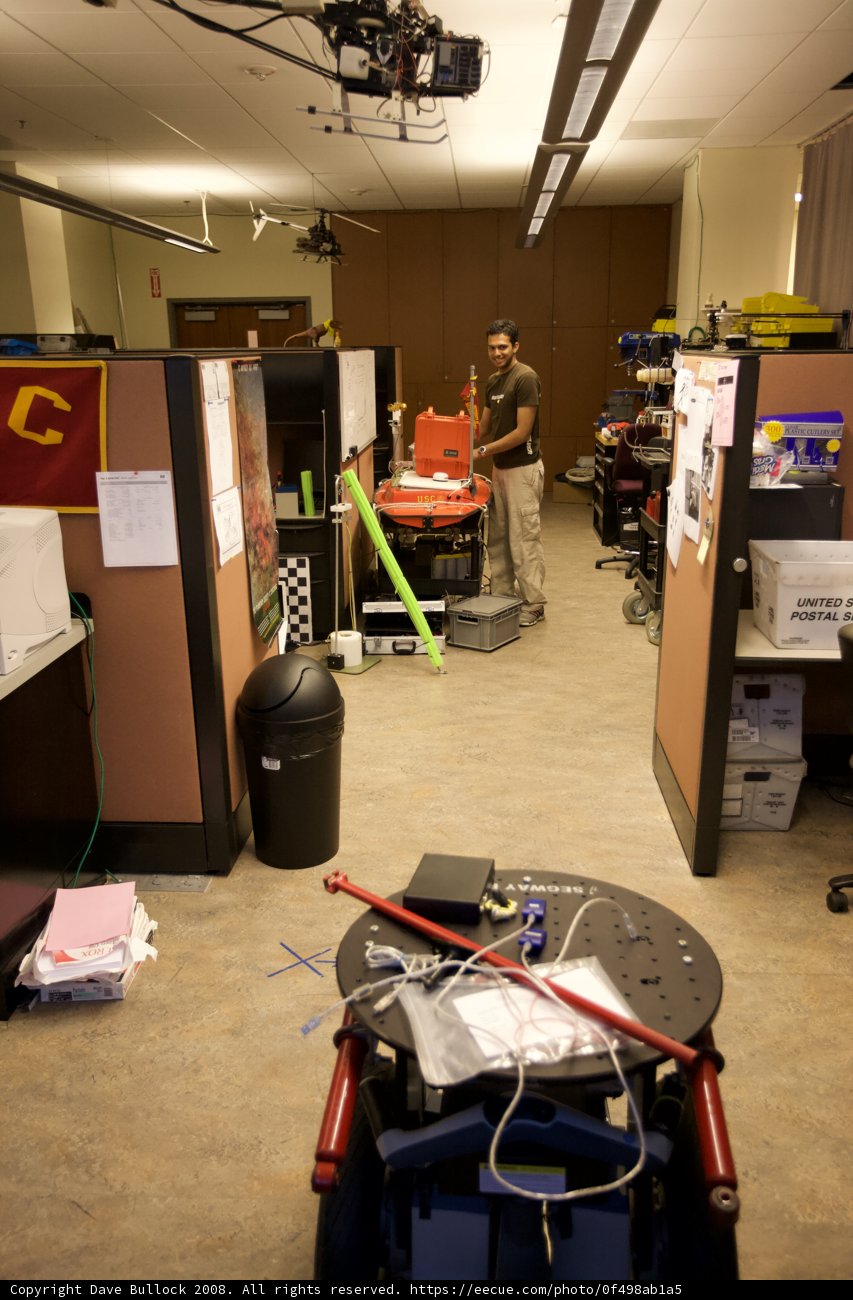 Man Standing Amidst Clutter in a Manufacturing Facility