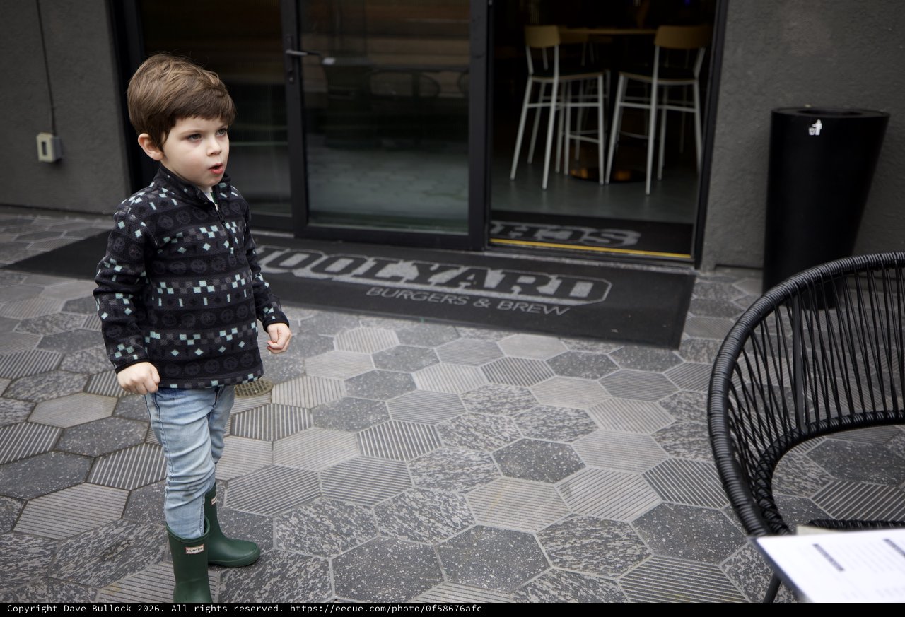 Young Boy Exploring Urban Restaurant Entrance