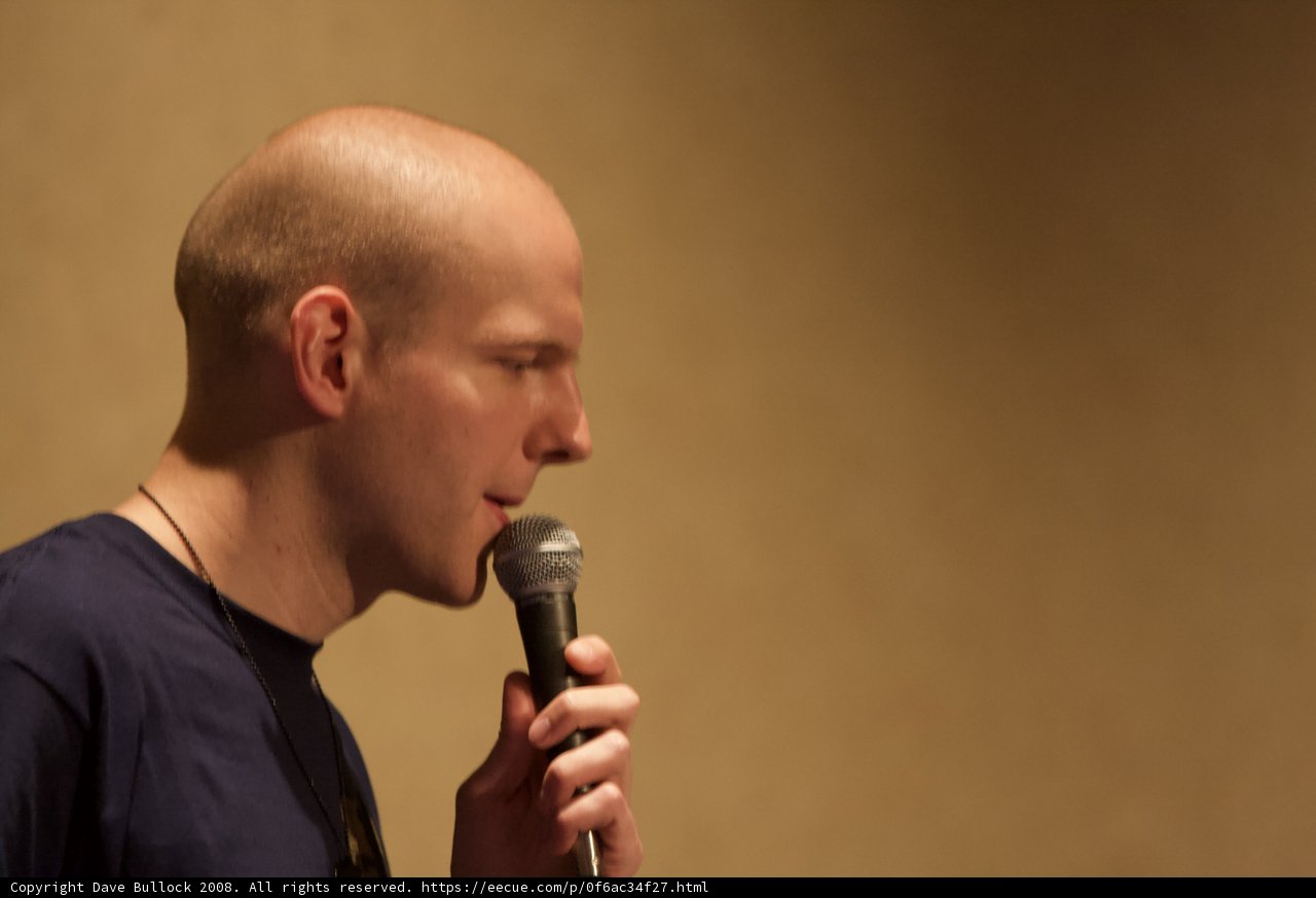 Bald Entertainer Holds Microphone for Solo Performance