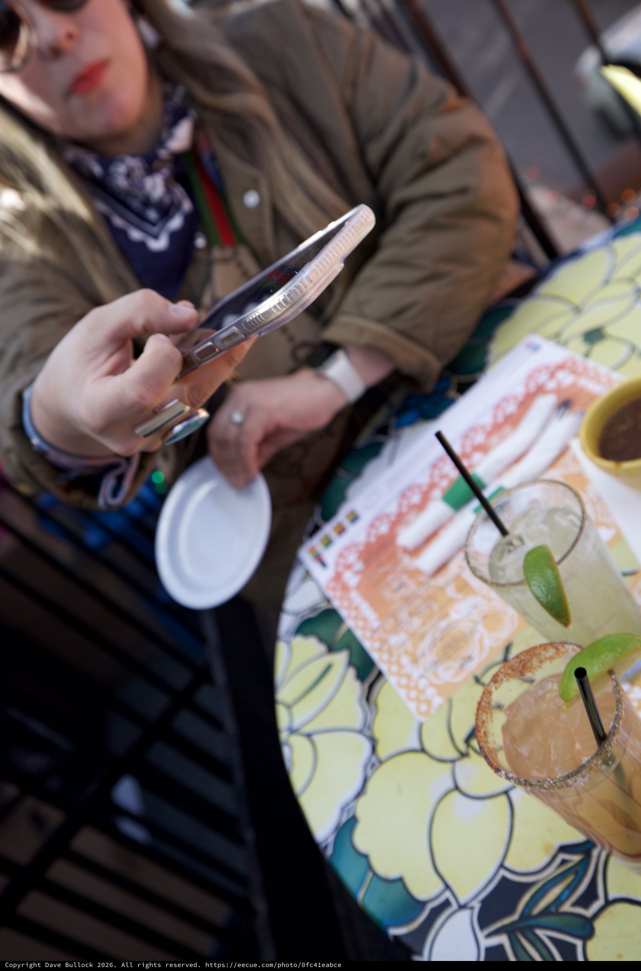 Scrolling Through Margaritas at Outdoor Cafe