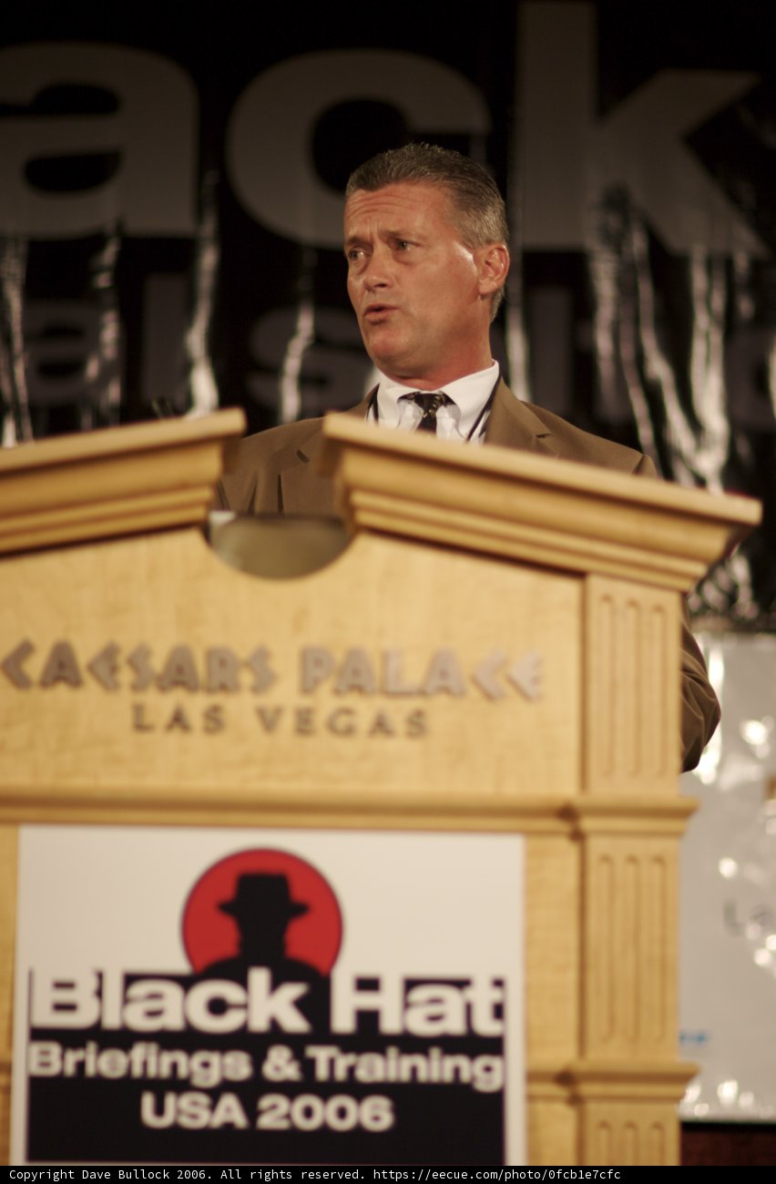 Man delivering a speech at a wooden podium