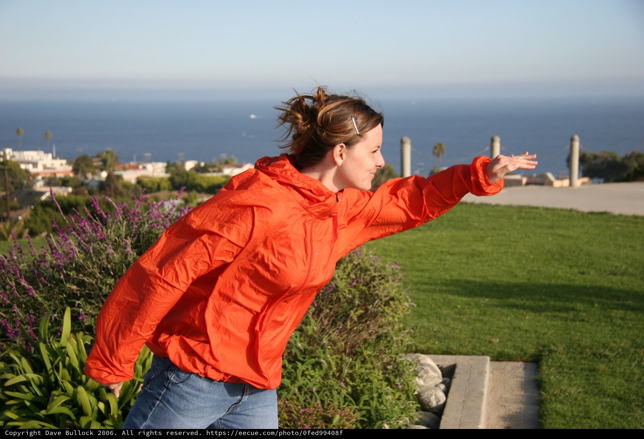 Woman in Red Jacket Embracing Ocean Breeze