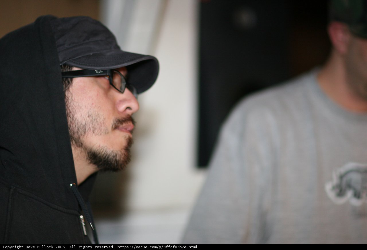 Hoodie-clad man sporting eyeglasses and baseball cap