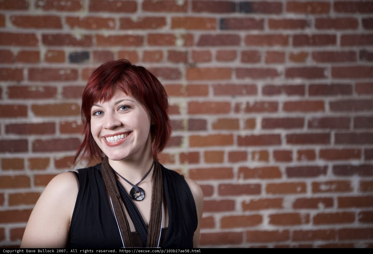 Red-Haired Woman Poses with Brick Wall