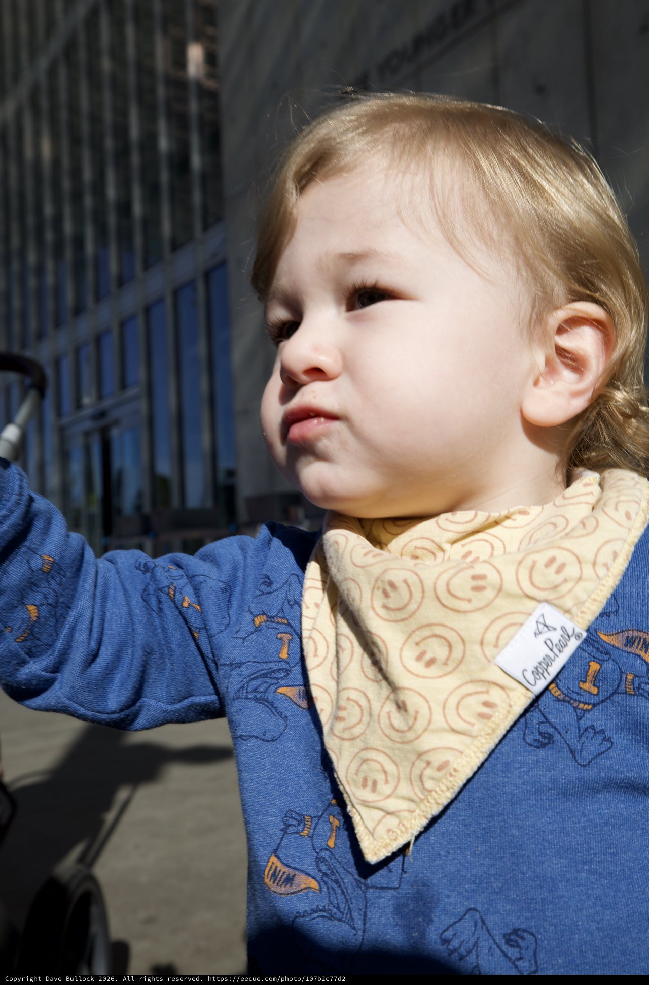 Young Child in Blue Patterned Outfit with Bib