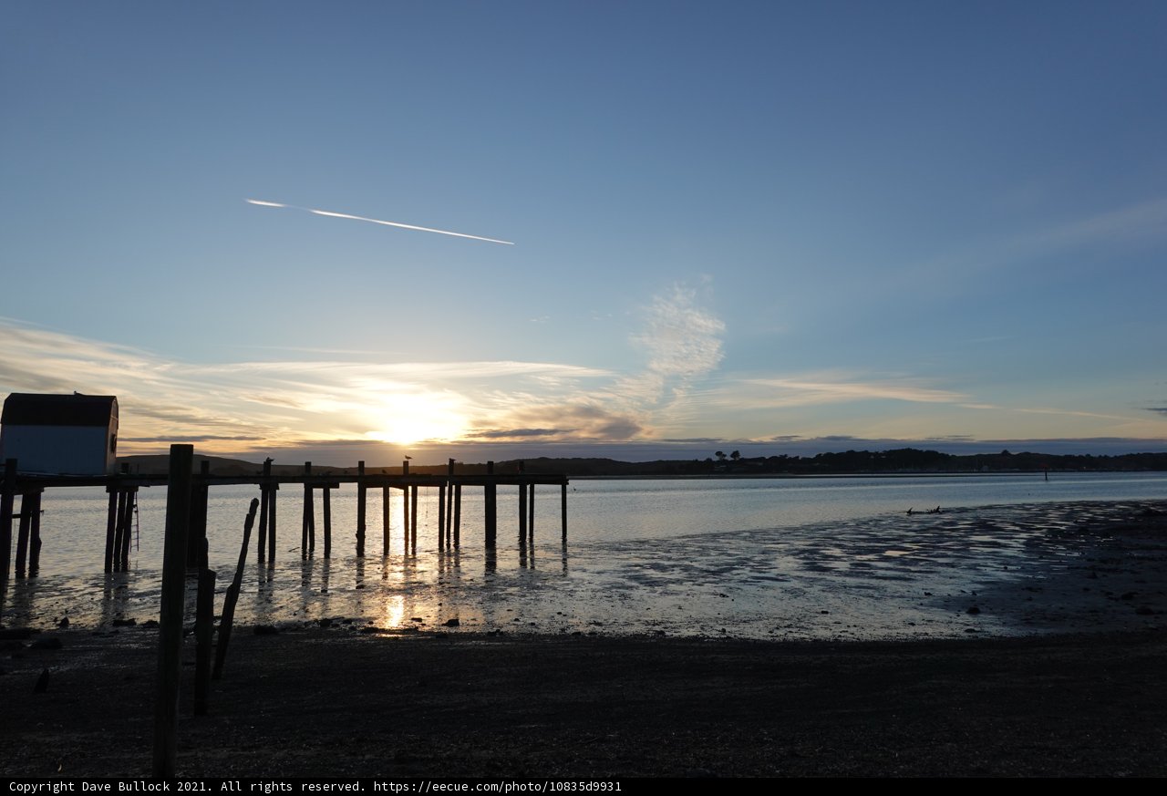 Pier at Sunset with a Jet Trail