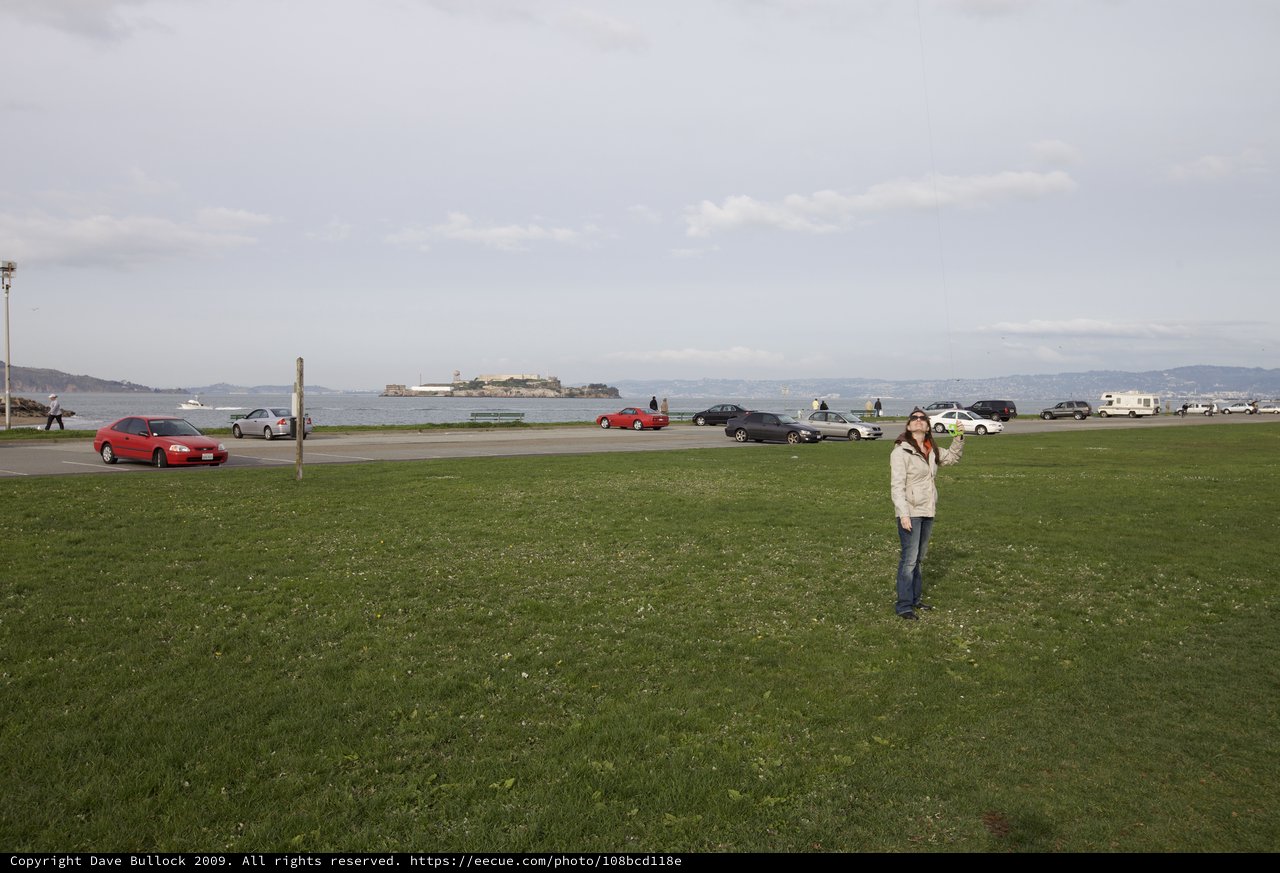 Woman Flying Kite with Alcatraz Island Behind