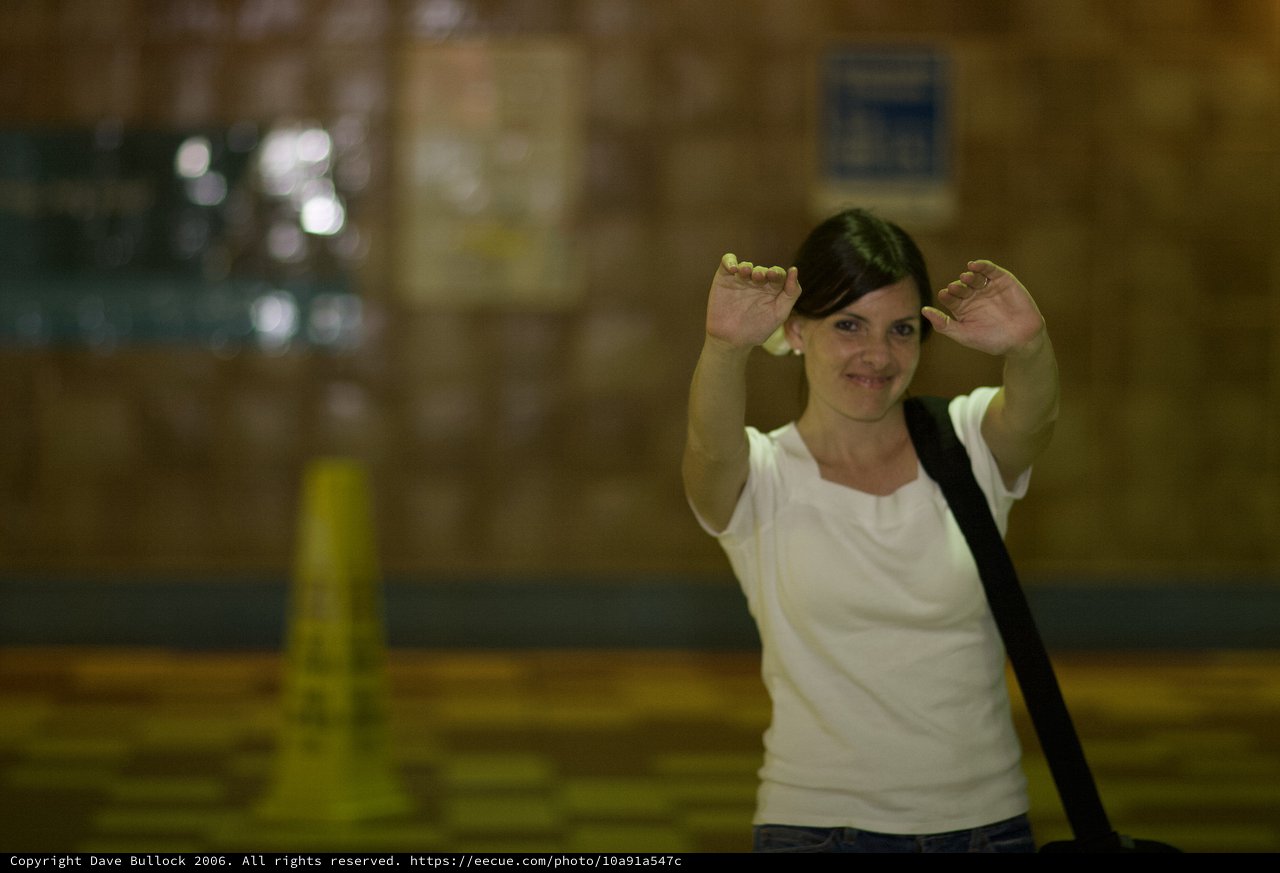 Playful Woman Making Bunny Ears in Warehouse