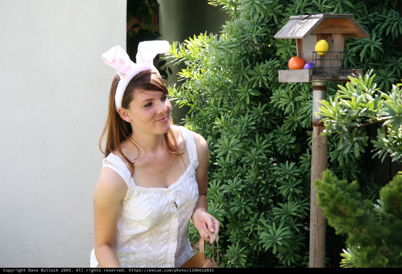 Easter Bunny Girl Beside Garden Bird Feeder