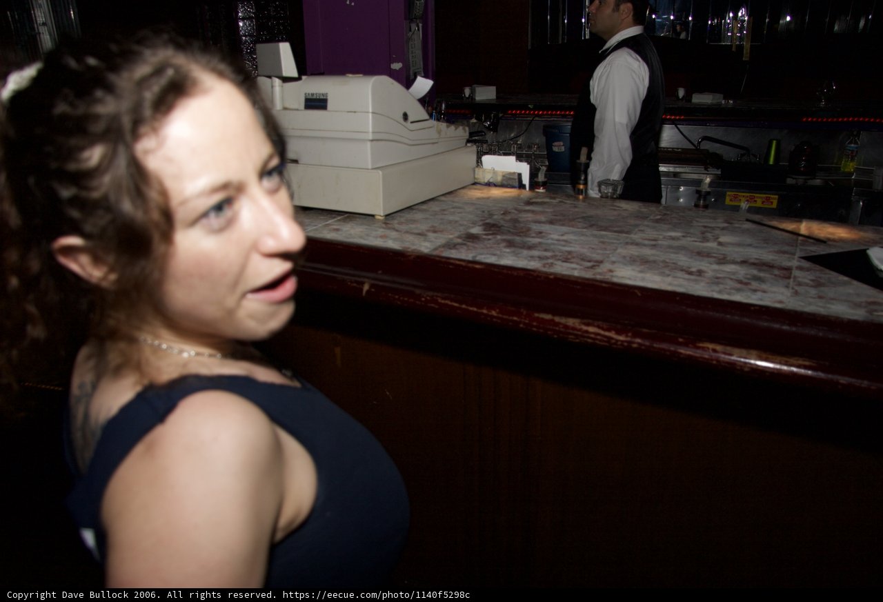 Two Adults Enjoying a Beverage at a Busy Bar