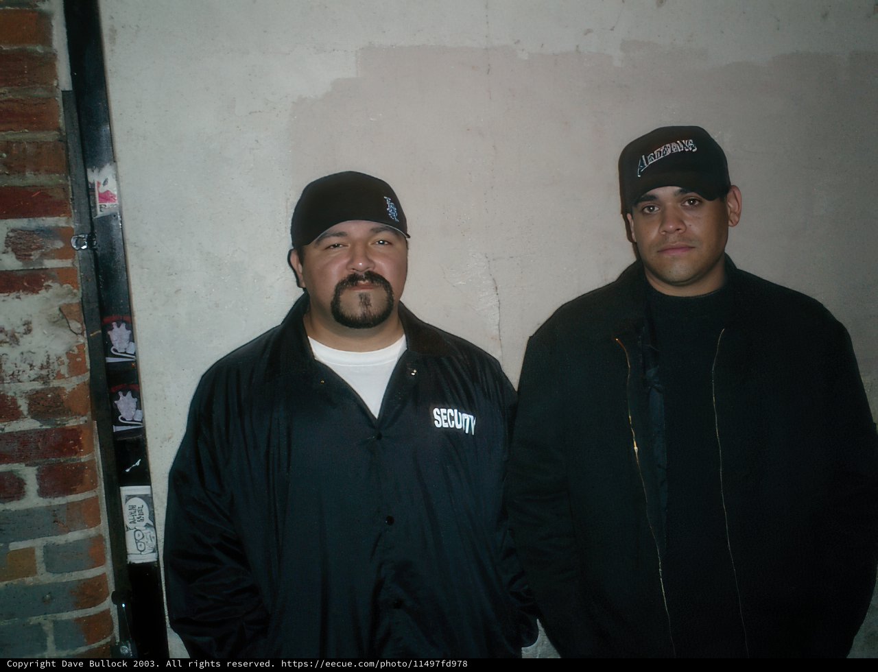 Two Men in Black Jackets Sporting Caps