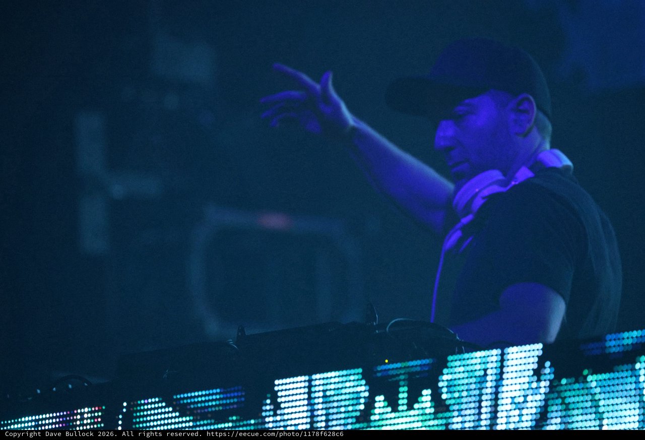 DJ Commands the Crowd Under Electric Blue Light
