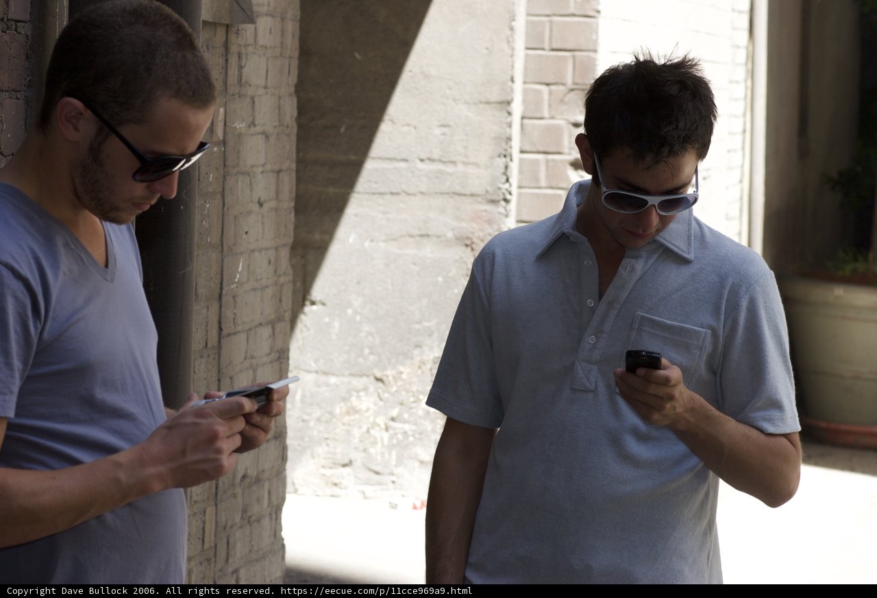 Two Men Checking Their Phones