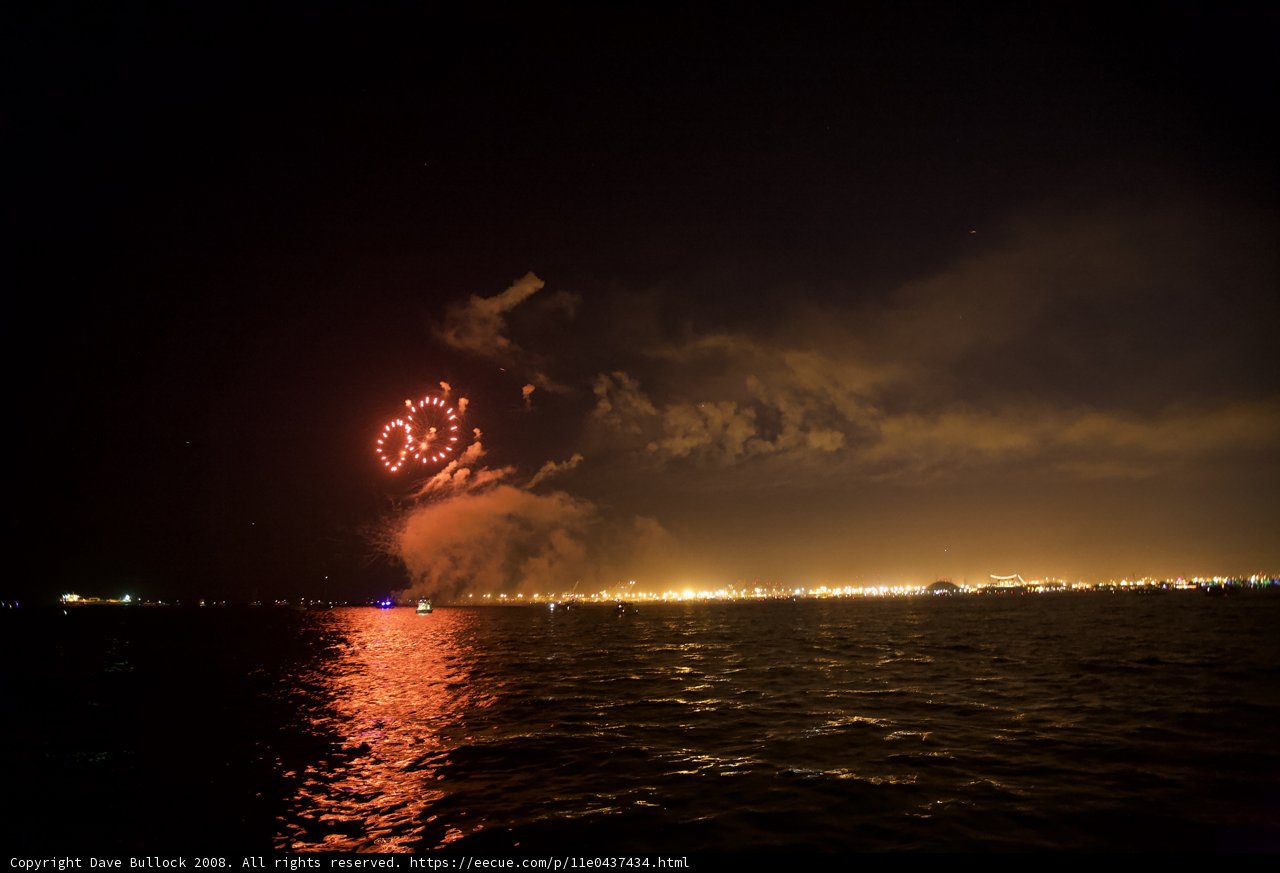 Bursting Fireworks over the Glittering Ocean
