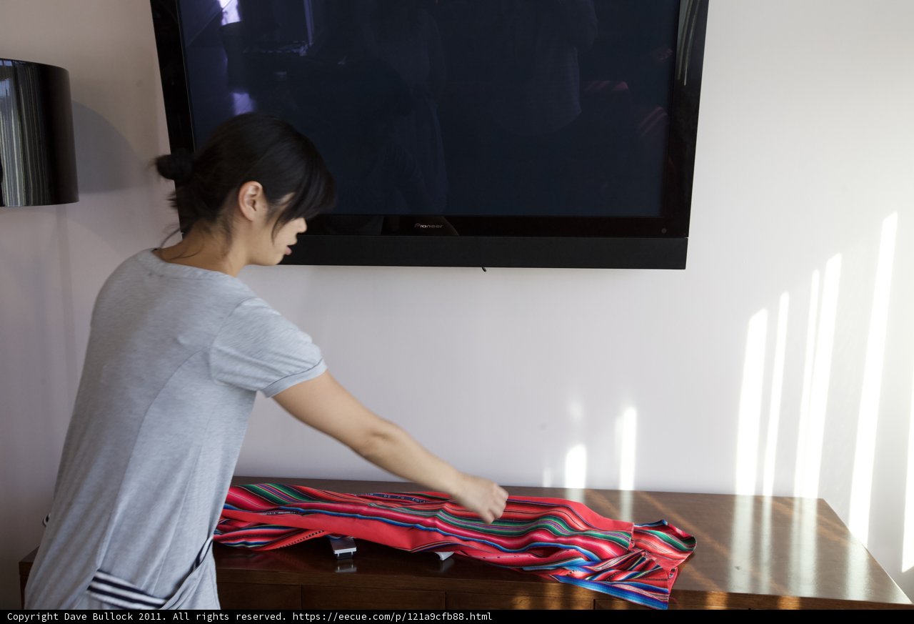 Woman Folding Clothes in a Modern Living Room