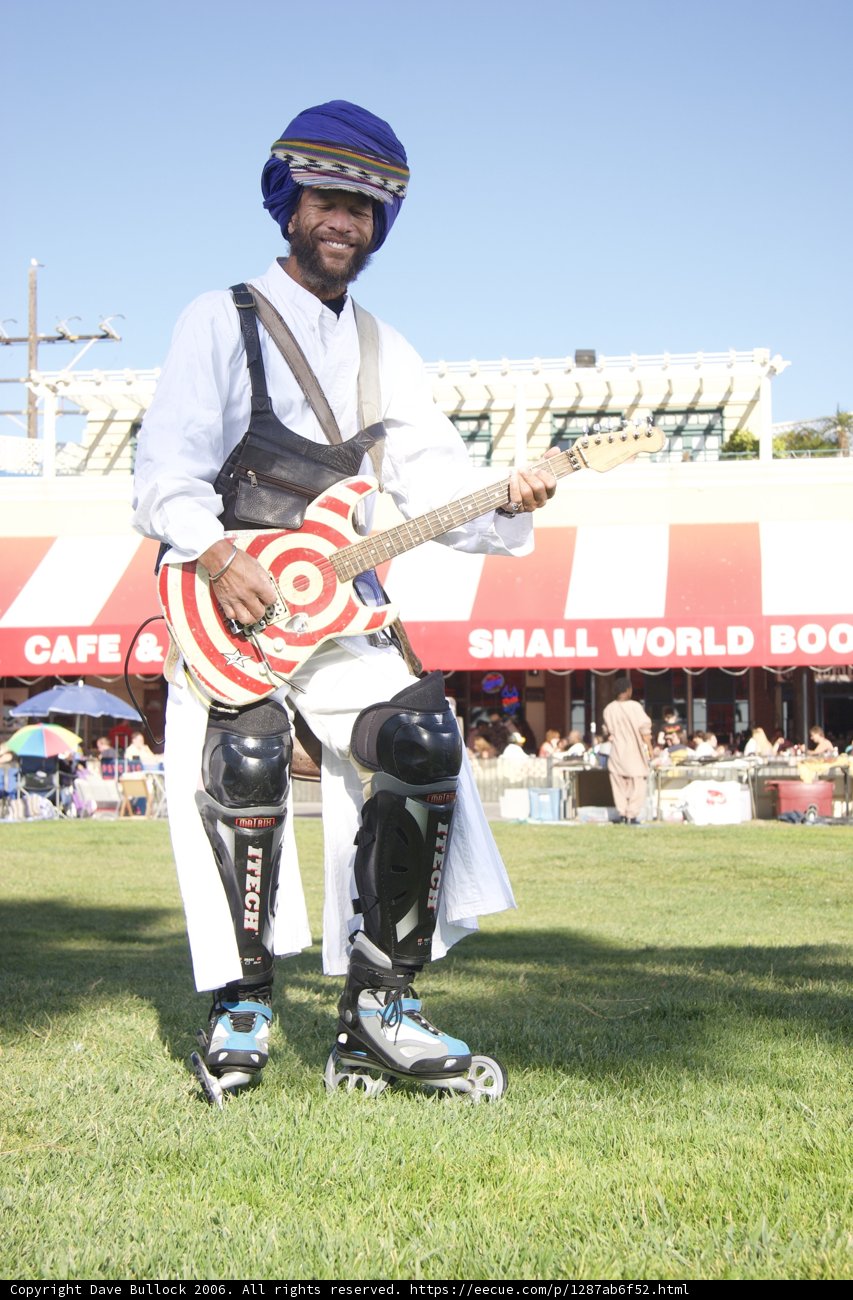 Helmeted Man Sits with Baseball Glove and Guitar